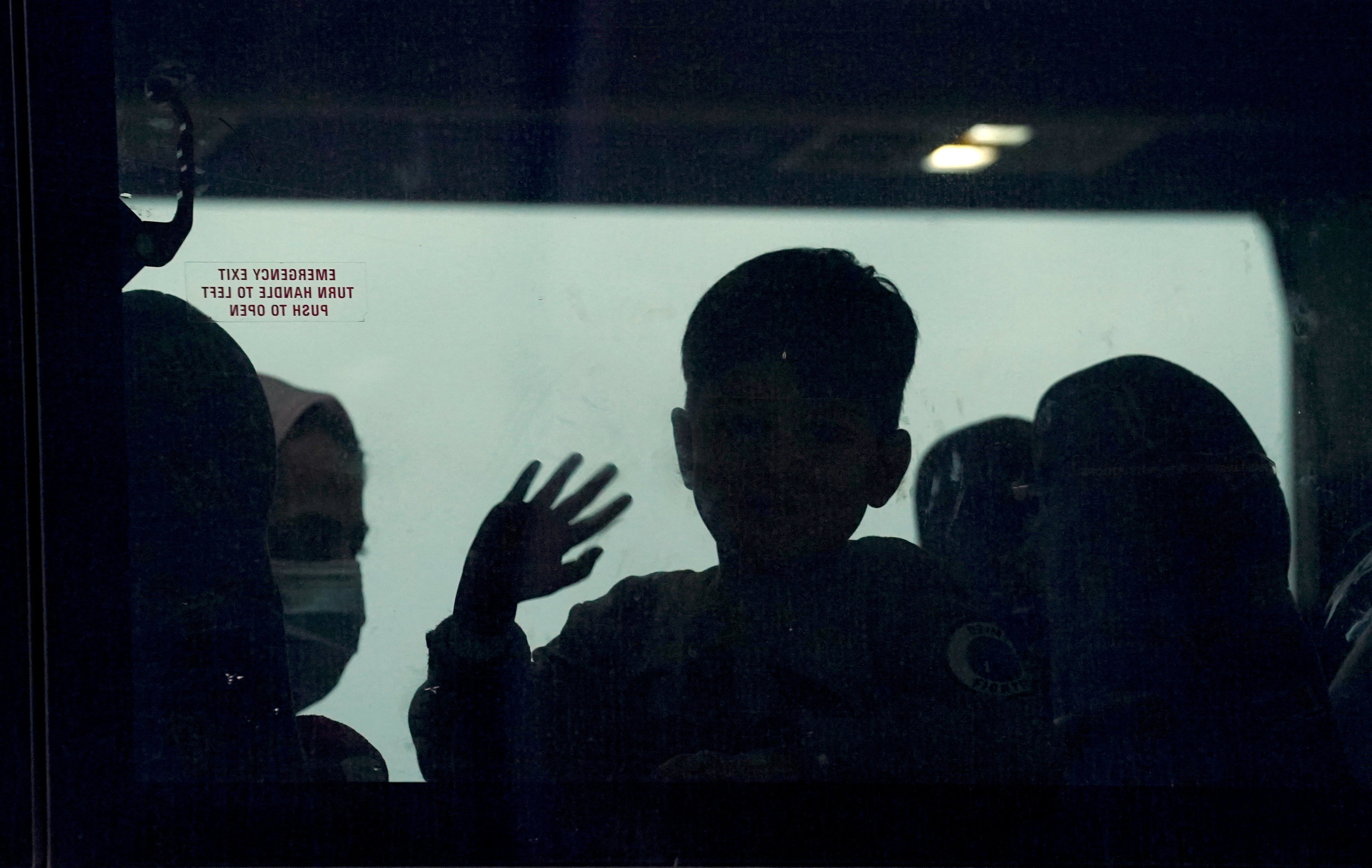 A day after US troops withdrew from Afghanistan in 2021, an Afghan boy waves from a bus taking refugees to a processing center upon their arrival at Dulles International Airport in Dulles, Virginia, United States. Photo: Reuters