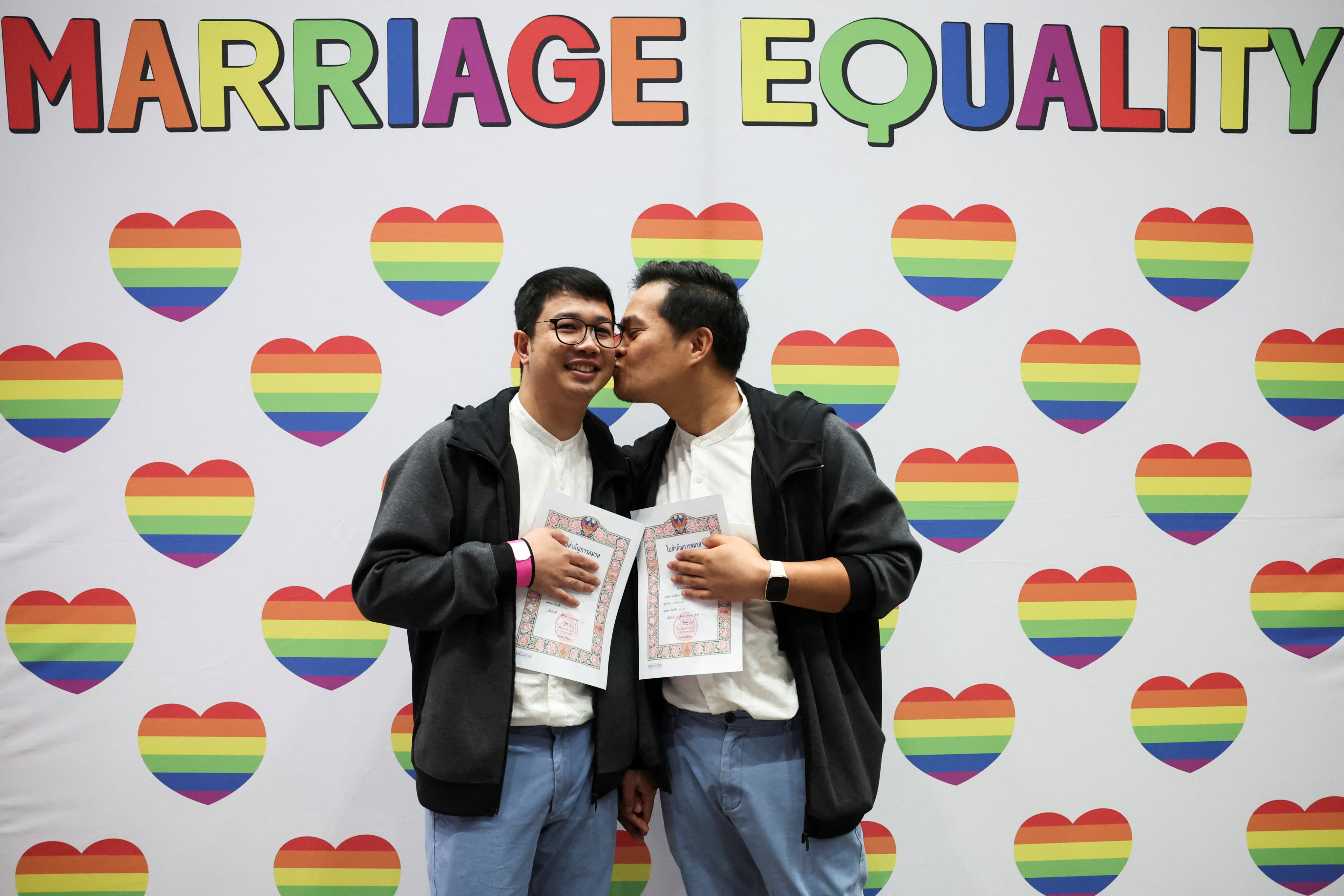 LGBTQ+ couple Chatchai Aunthaya, 40, and Nitinai Buathong, 32, pose for photos after they receive official marriage certificates in Bangkok, Thailand, on Thursday. Photo: Reuters