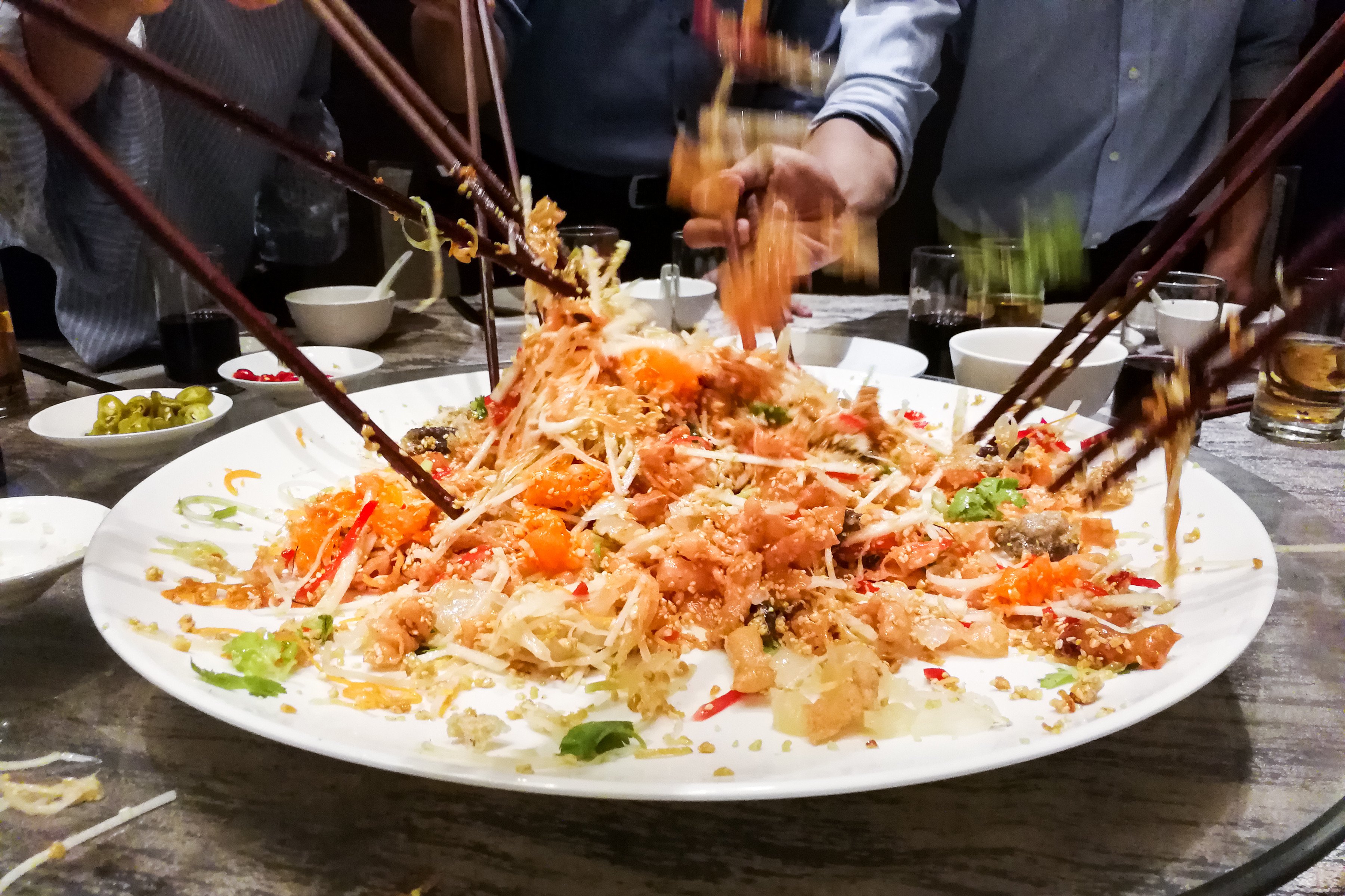 People tossing the ingredients of “yusheng”, or prosperity toss salad, during Chinese New Year, a traditional practice in Malaysia and Singapore for luck and prosperity. Photo: Shutterstock