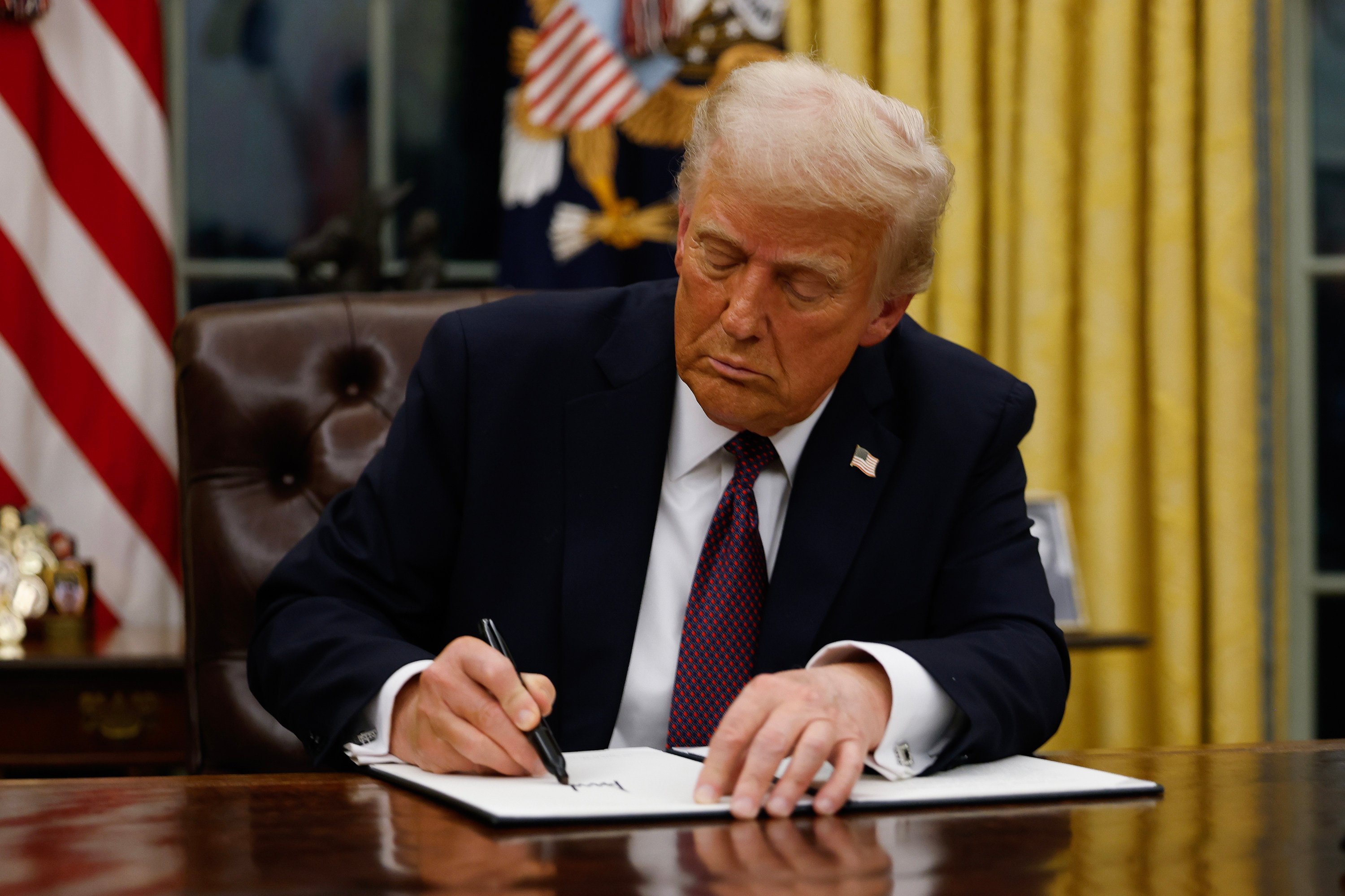 US President Donald Trump signing executive orders at the White House on Monday. Photo: Getty Images/TNS