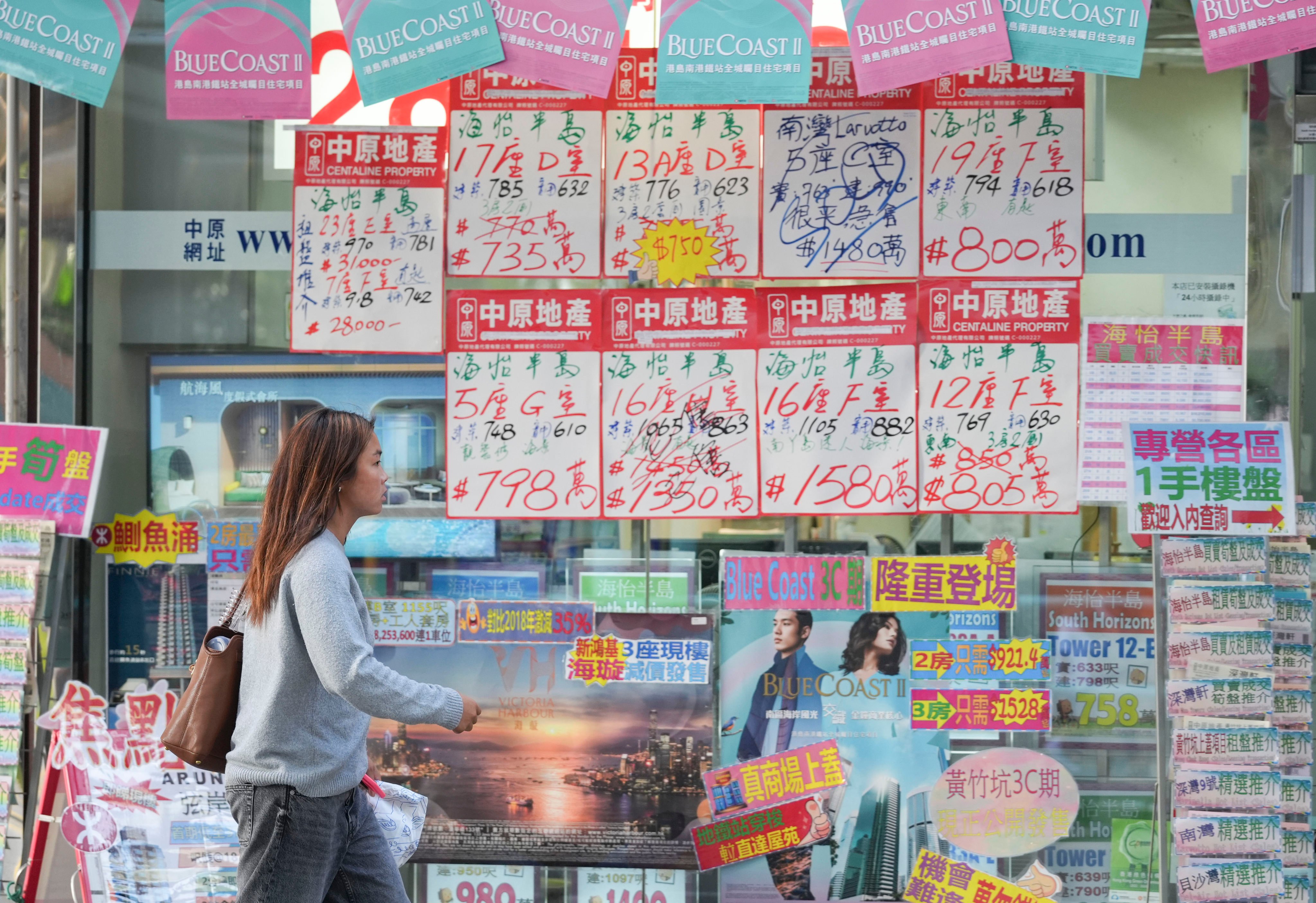 A woman walks past a property agency in South Horizons, Hong Kong. Photo: Eugene Lee