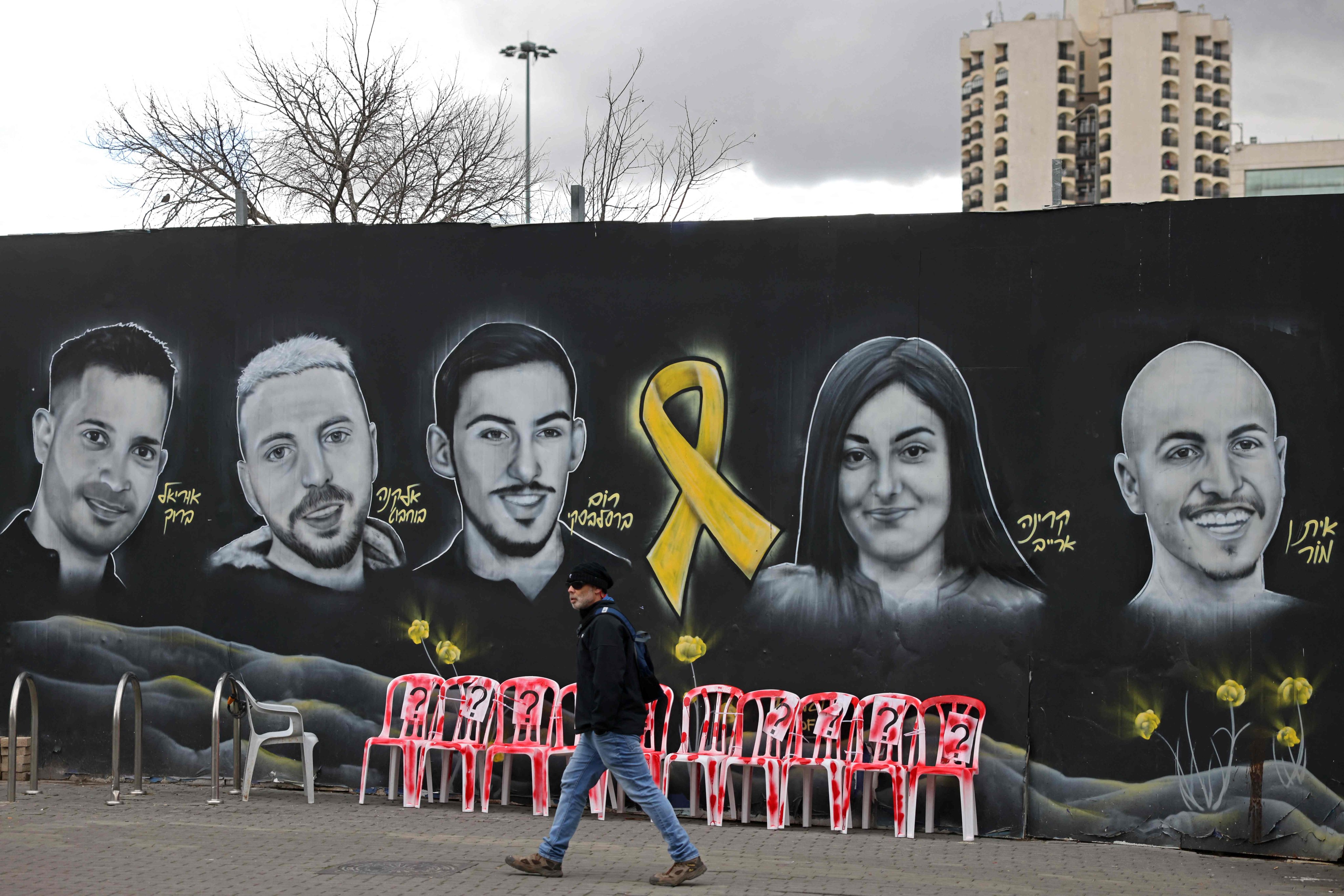 A pedestrian walks past a Jerusalem mural on Friday showing portraits of Israeli hostages held in the Gaza Strip since the October 7, 2023 attacks by Hamas militants. Photo: AFP