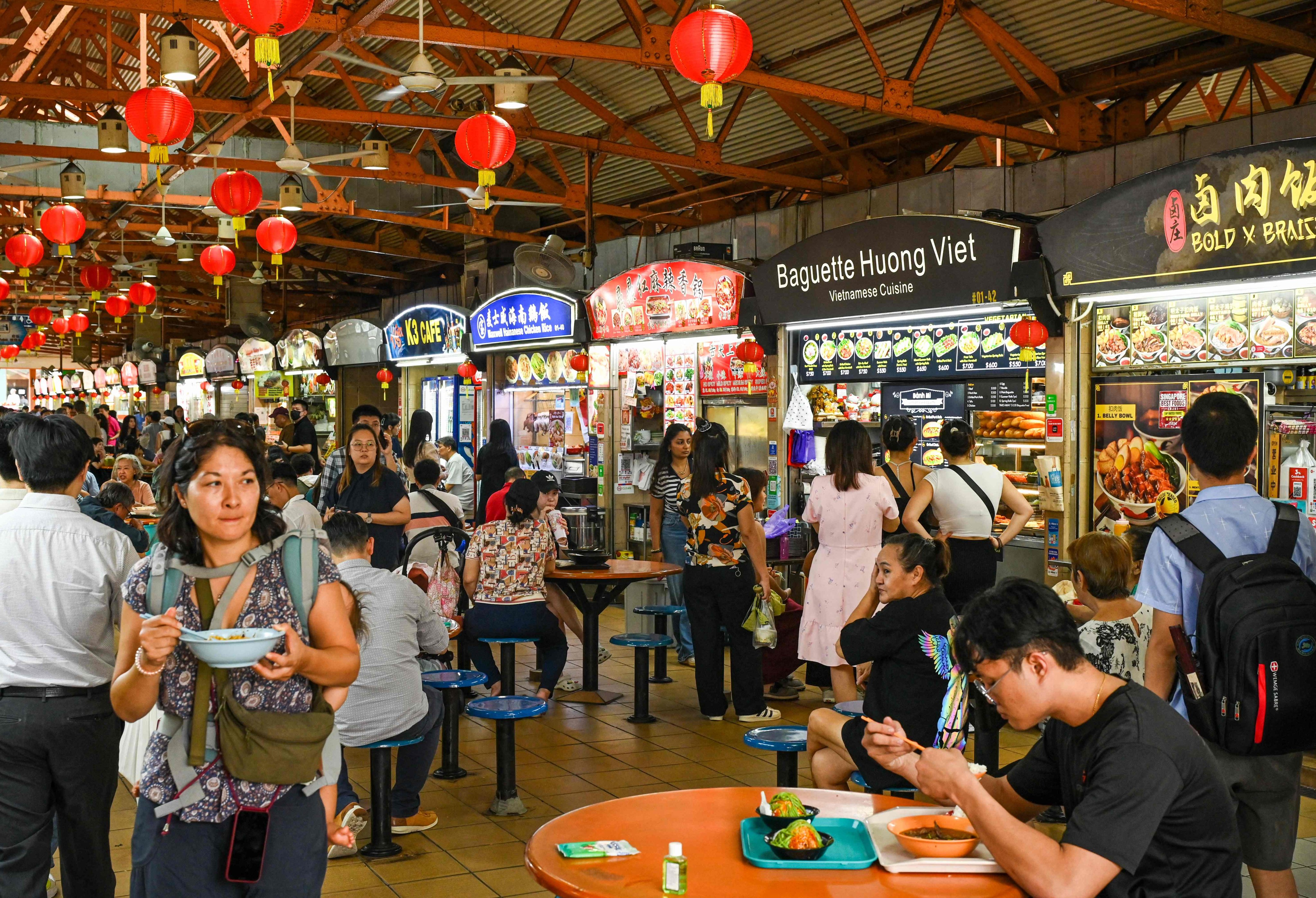 People buy food for lunch at a hawkers centre in Singapore. Photo: AFP