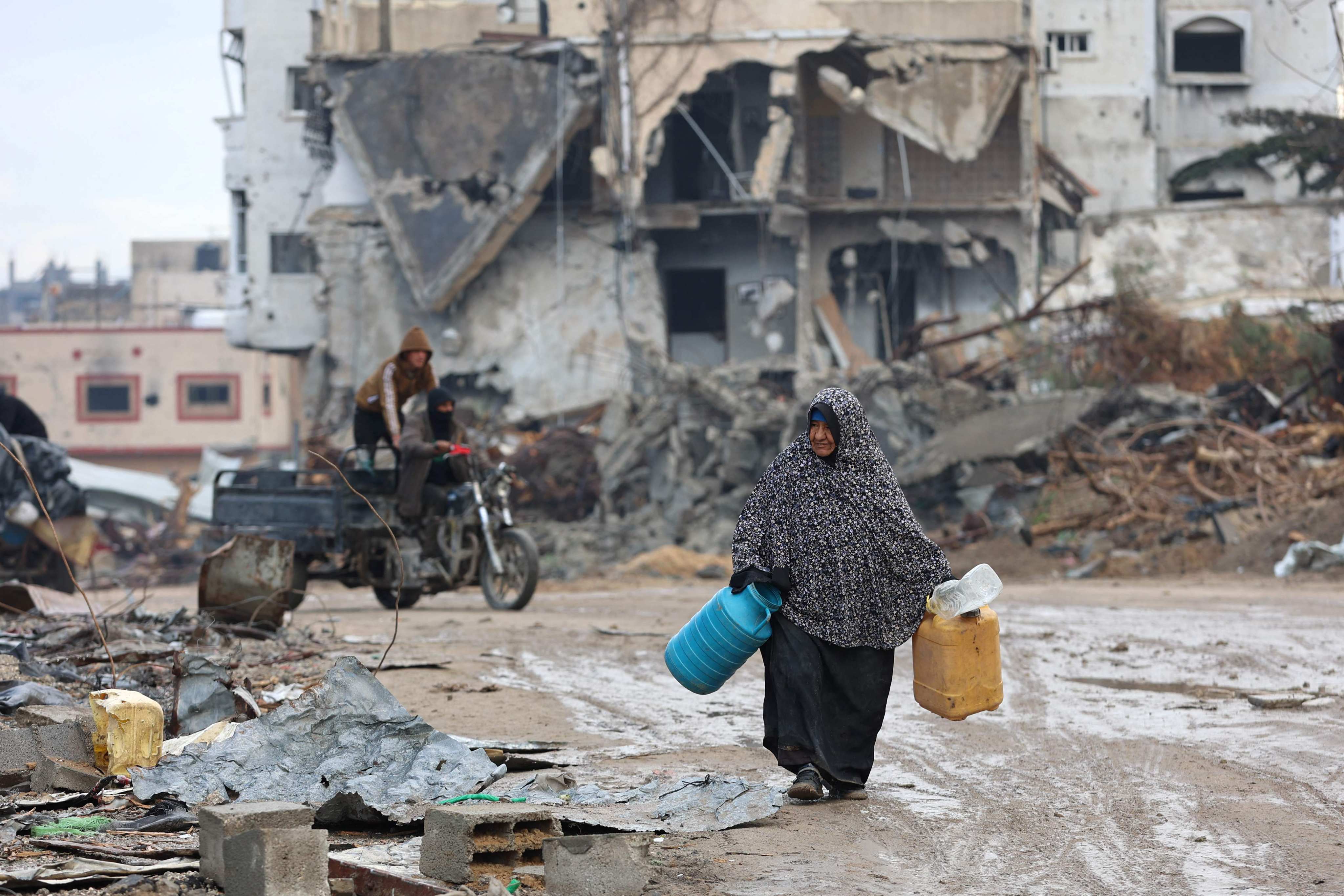 A woman walks past building rubble as displaced Palestinians return to the northern areas of the Gaza Strip, in Jabalia, on Thursday, during a ceasefire in the war between Israel and Hamas. Photo: AFP