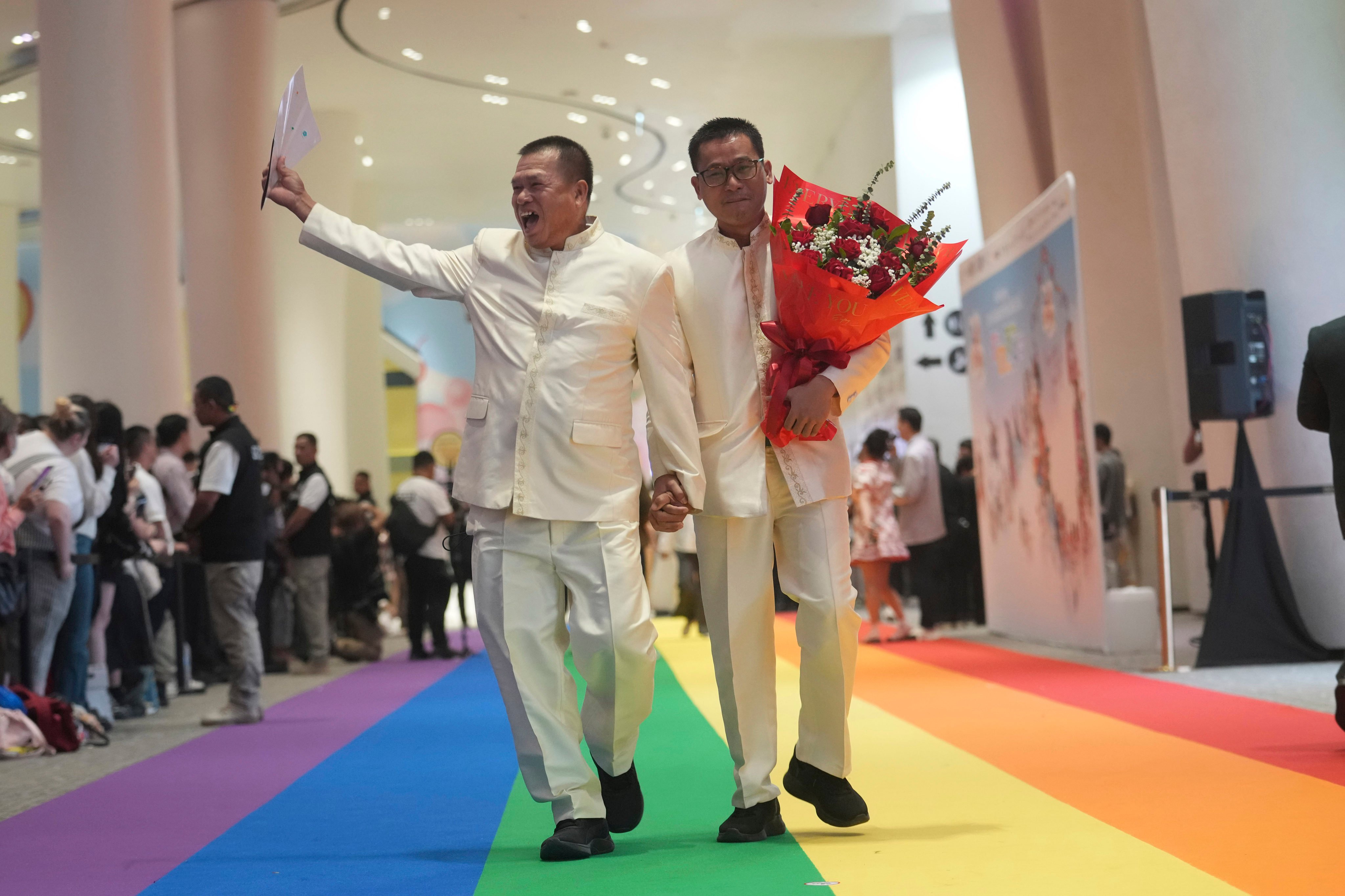 A just-married couple walks on a rainbow carpet in Bangkok, Thailand, on January 23, 2025, the first day a marriage equality law took effect. Photo: AP