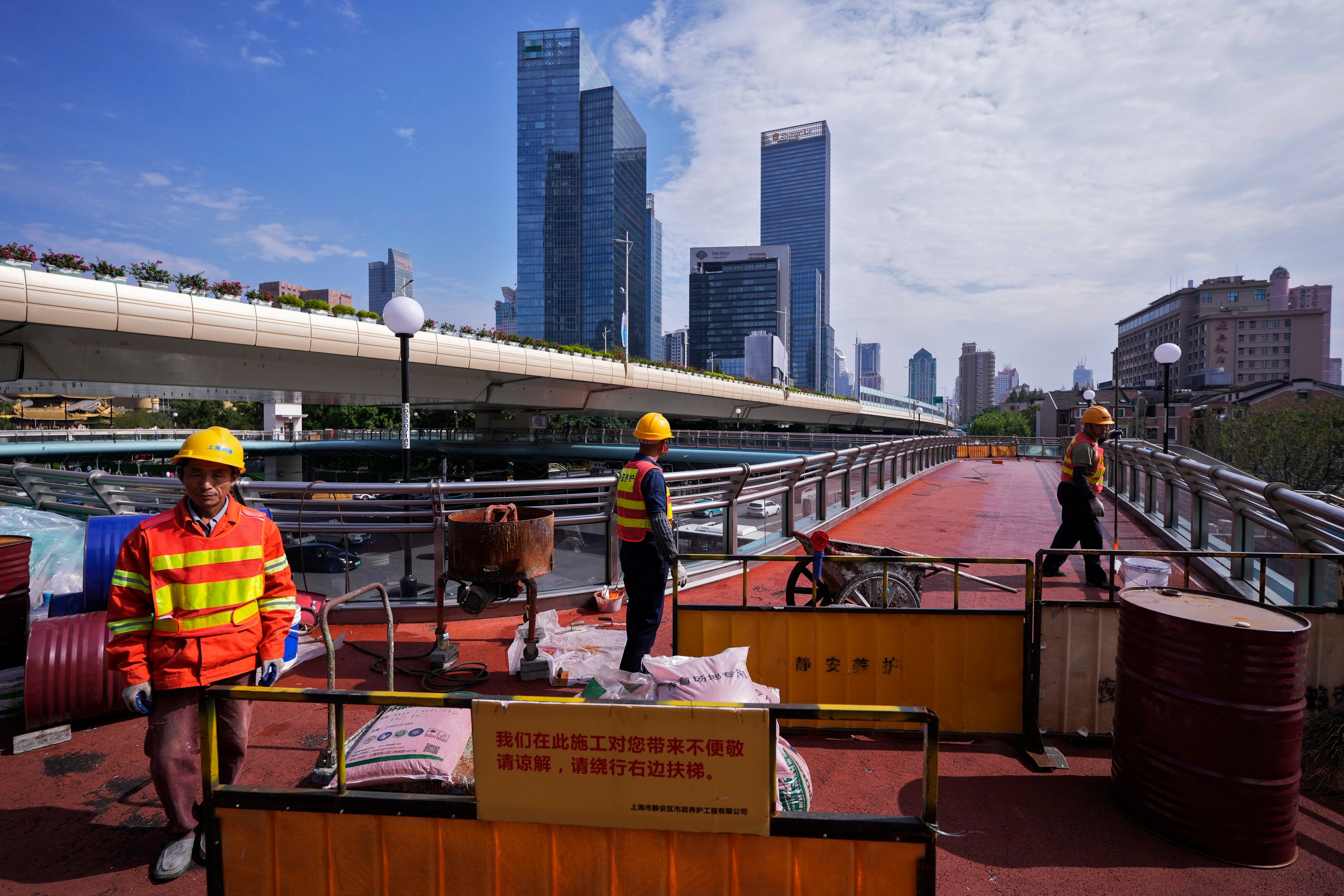 Workers refurbish an overhead pedestrian bridge in Shanghai on October 9, 2024. Photo: AP