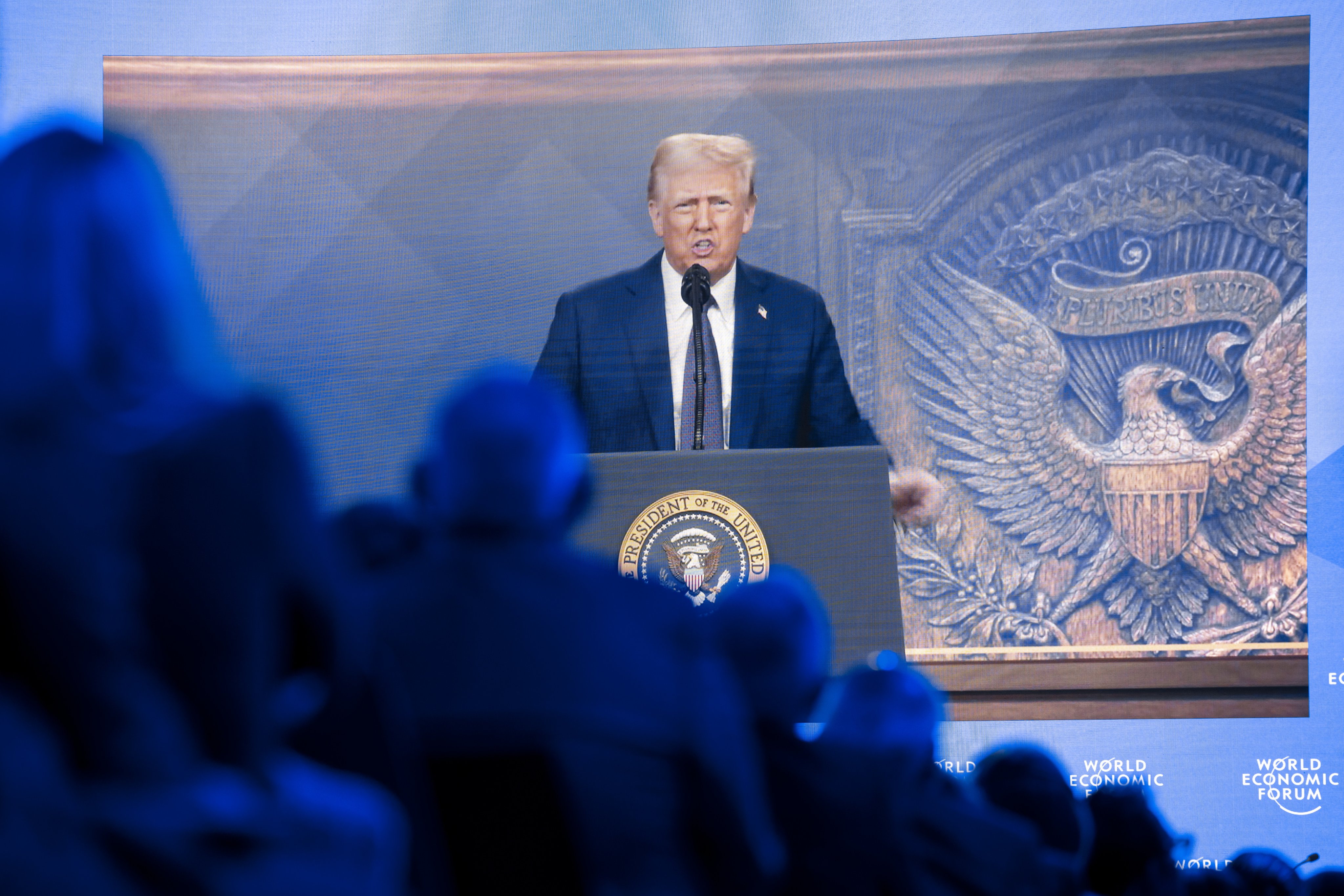 Trump is shown on screens as he addresses the WEF via remote connection. Photo: EPA-EFE