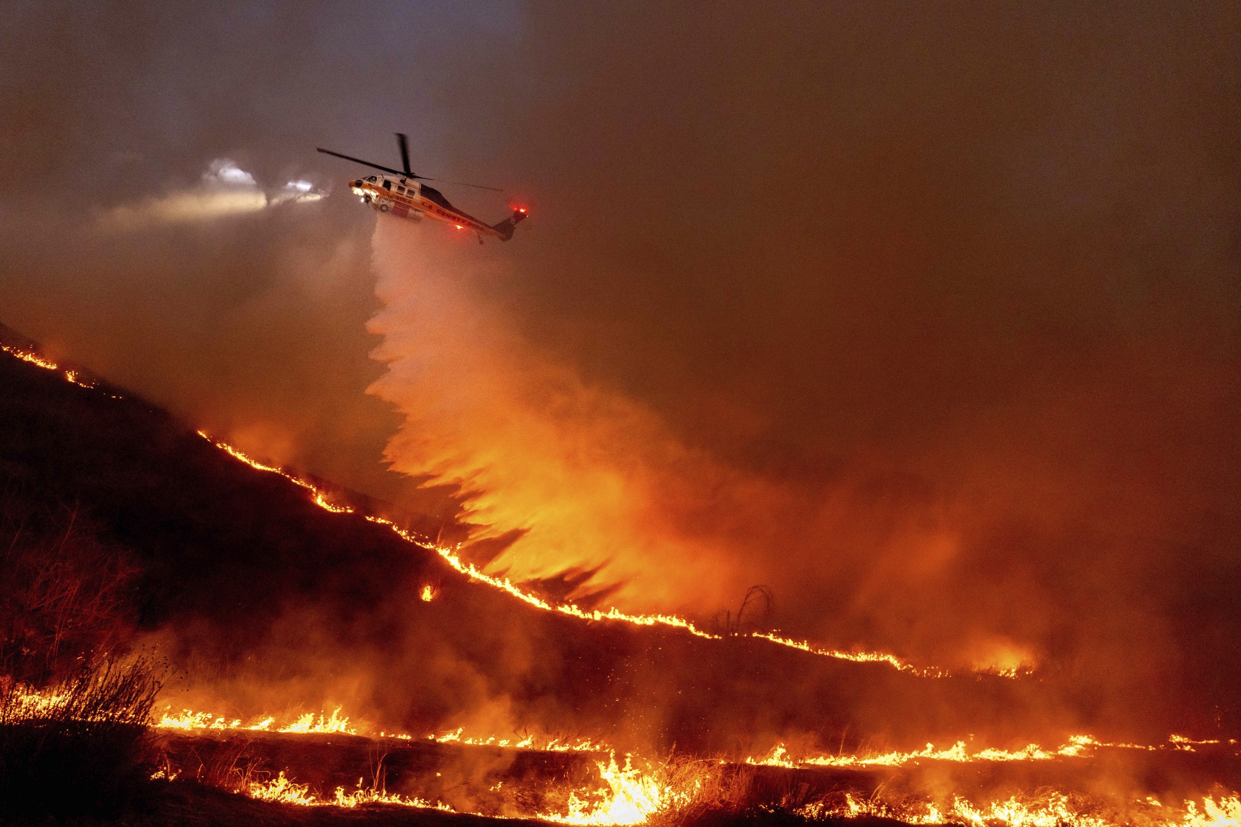 Water is dropped by helicopter on Los Angeles, where wildfires this month were exacerbated by drought. Photo: AP