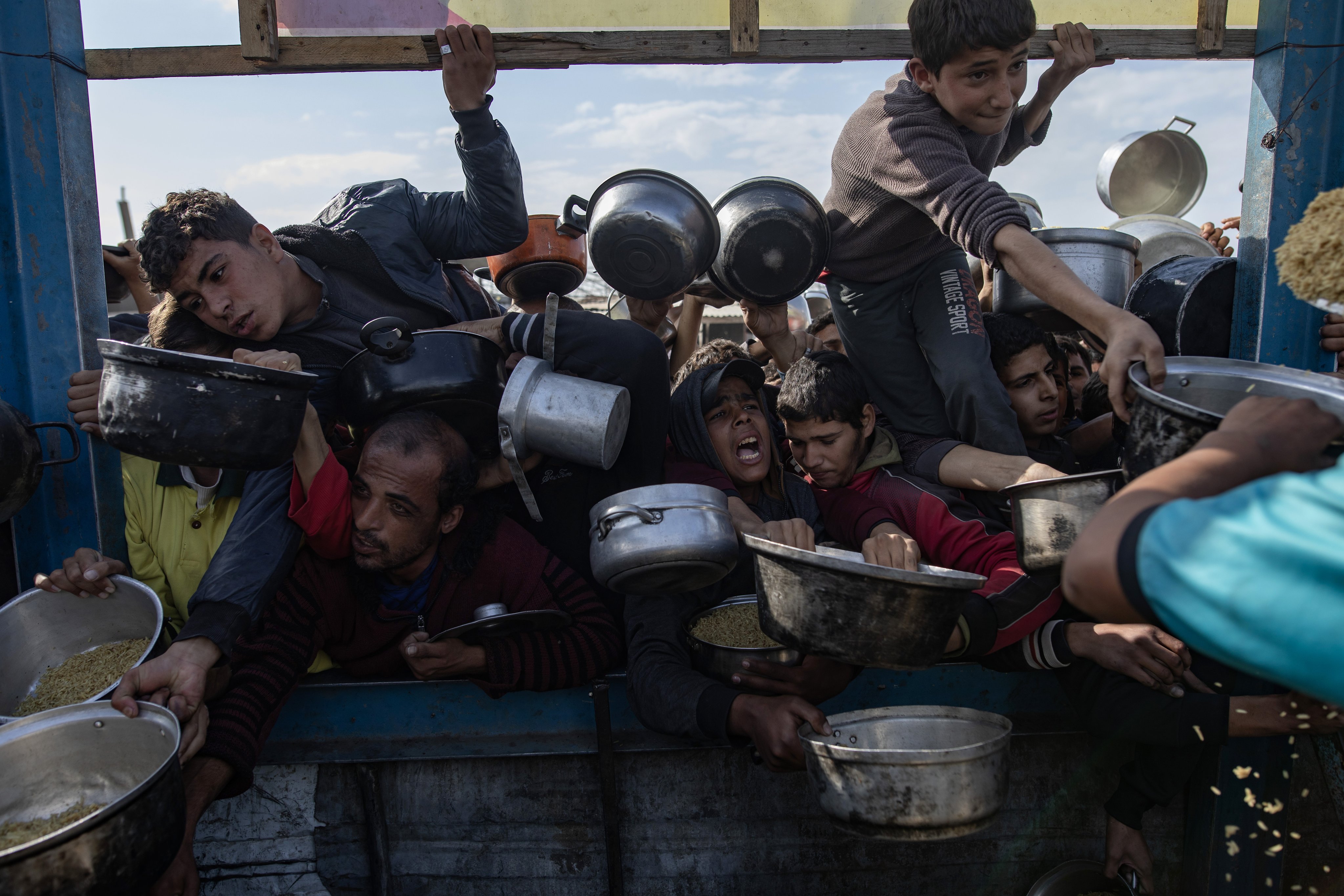 Palestinians gather to receive food cooked by a charity kitchen, in Khan Yunis, Gaza Strip. Photo: EPA-EFE