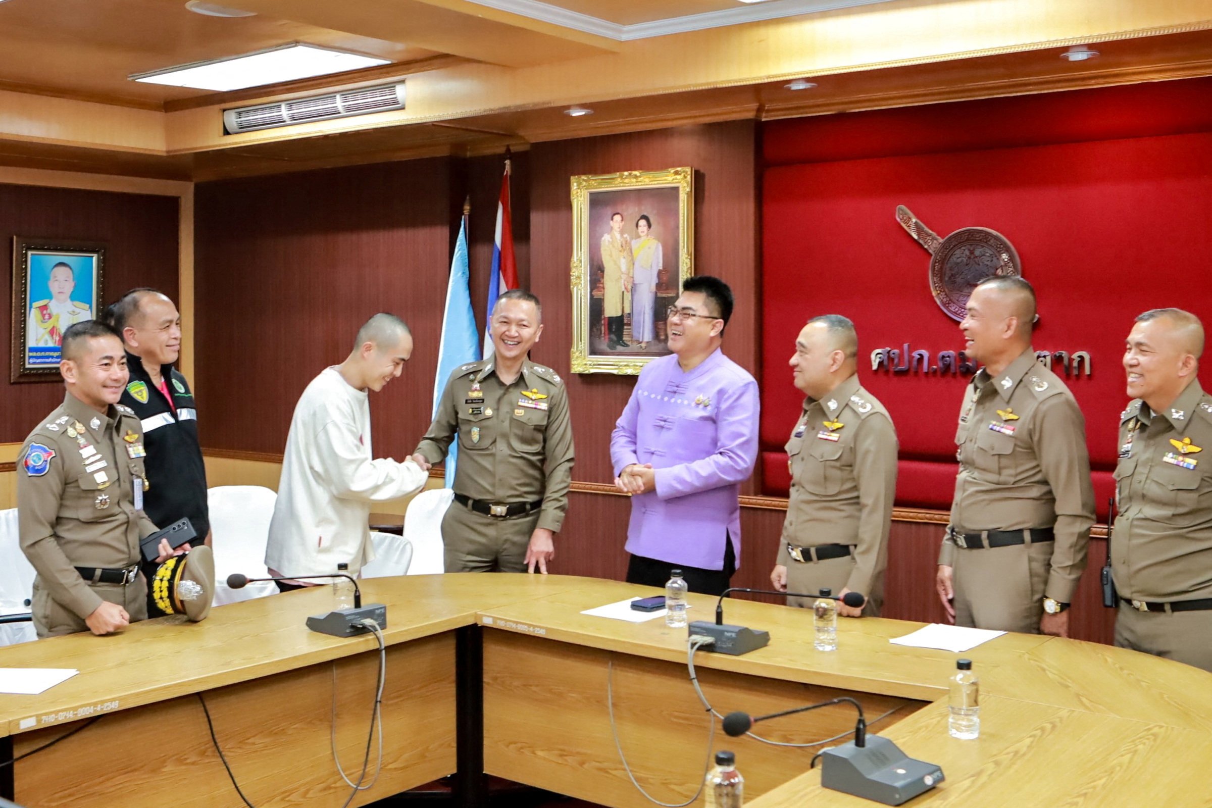 Wang Xing shakes hands with a Thai police officer after his rescue. Photo: Reuters