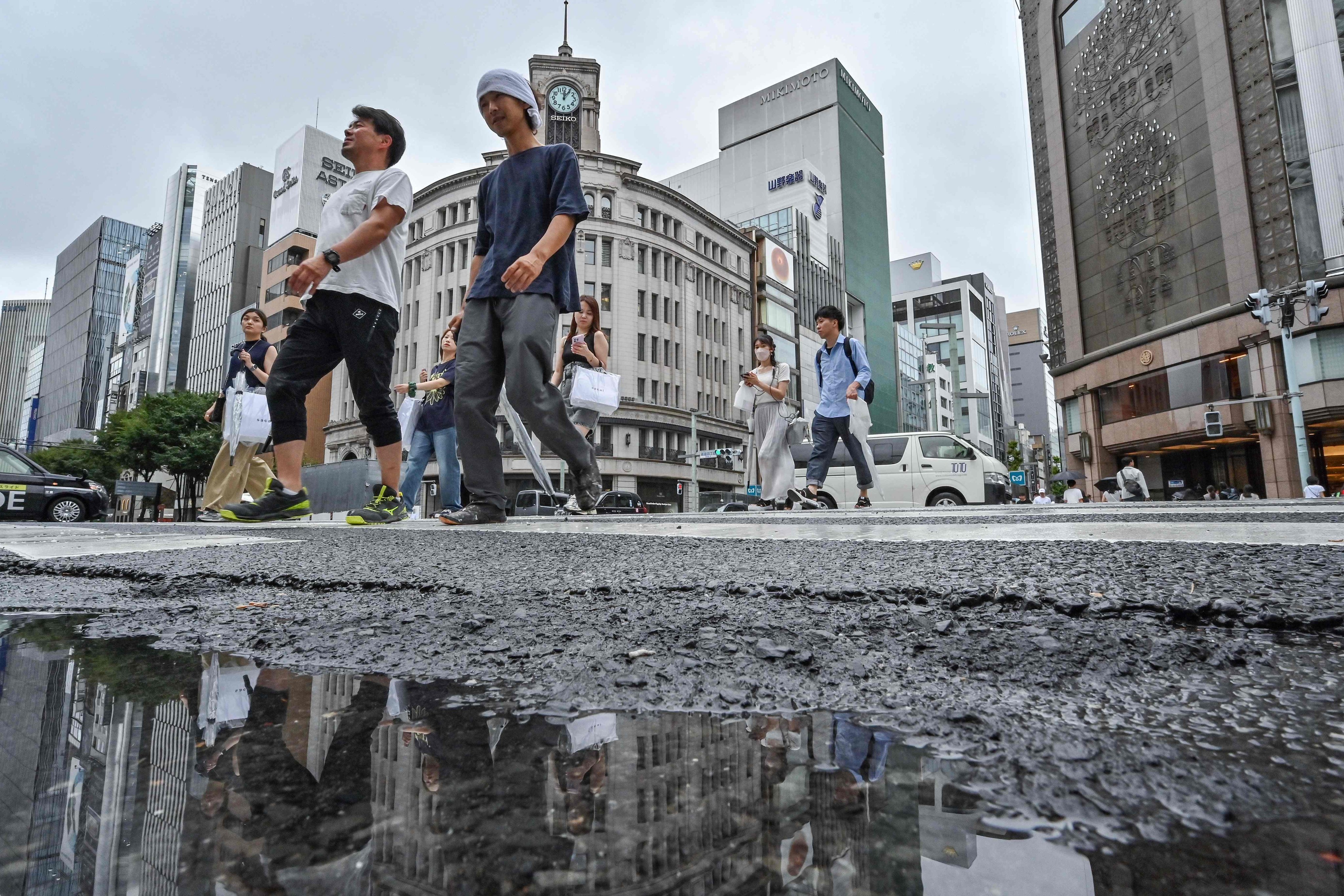 Pedestrians cross the street in the popular shopping district of Ginza, in central Tokyo, on August 16, 2024. Photo: AFP