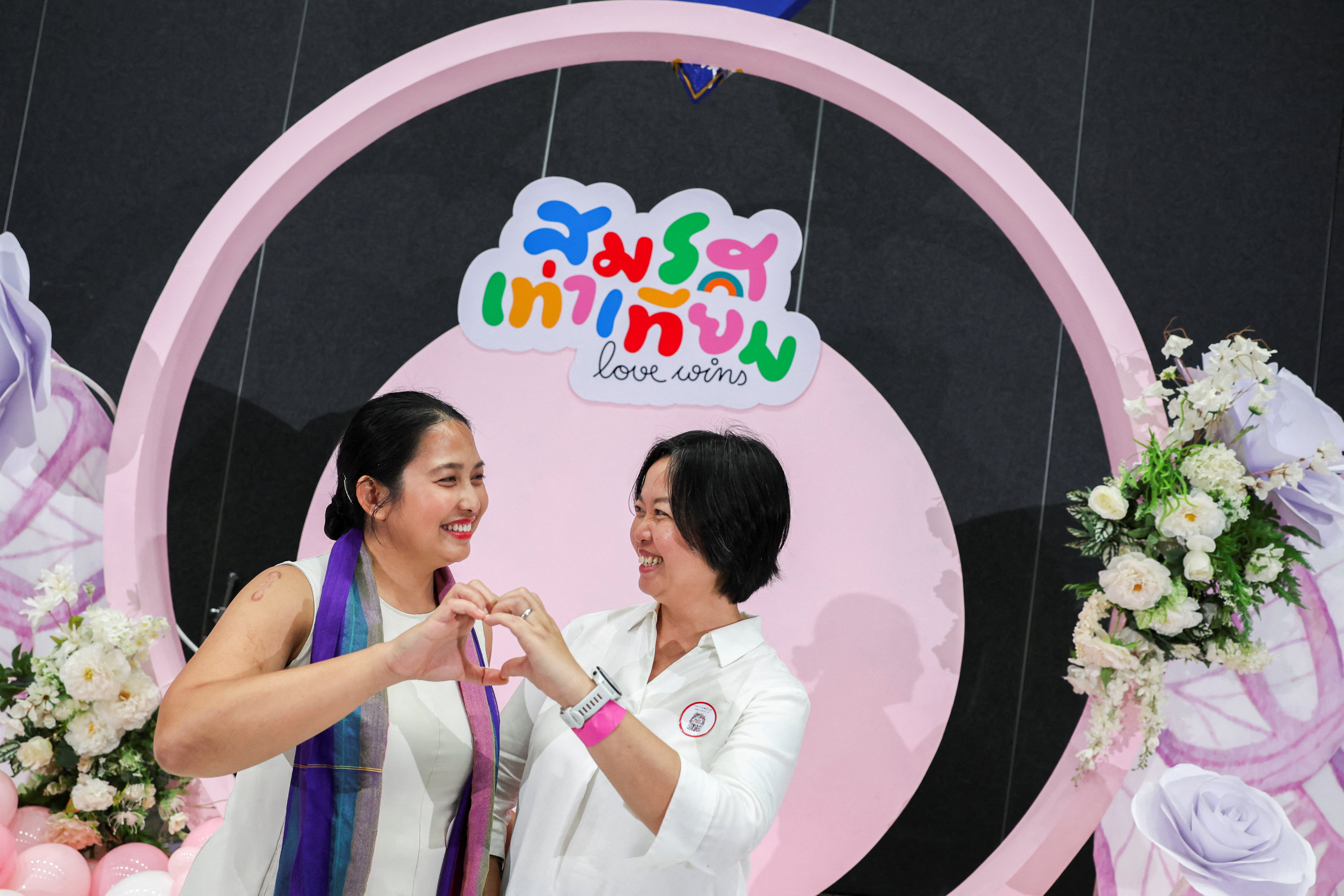 LGBTQ couple Vorawan “Beaut” Ramwan and Anticha “An” Sangcha pose for photos after receiving official marriage certificates in Bangkok, Thailand. Photo: Reuters