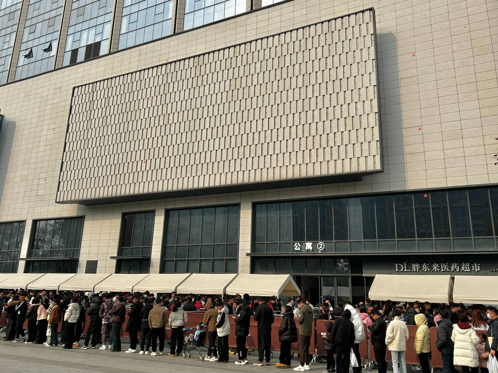 Dozens of customers wait outside of a Pangdonglai supermarket in Xuchang, Henan province. Photo: Alice Li