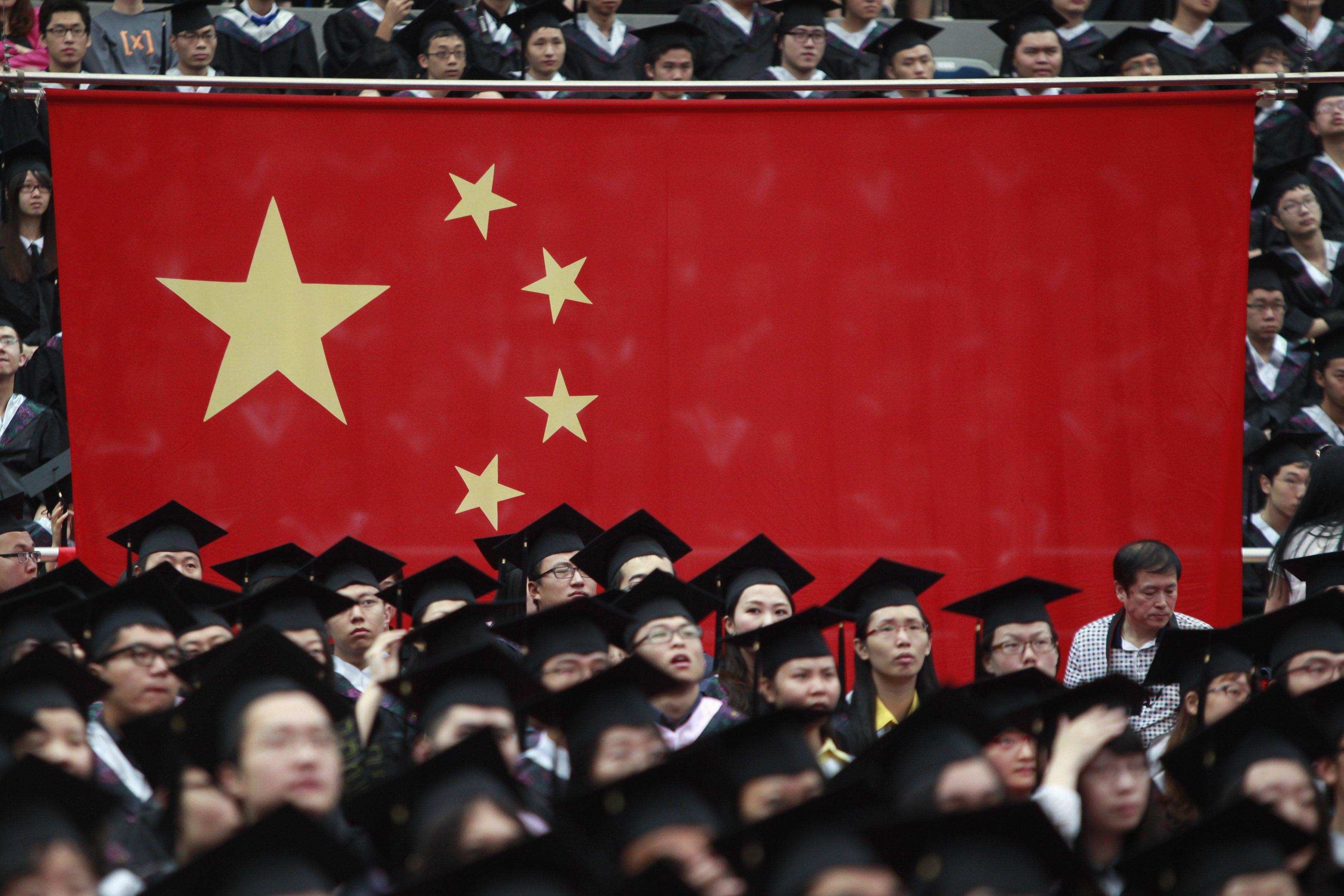 Graduates sit by a Chinese flag during a graduation ceremony at Fudan University in Shanghai, in June 2013.  Photo: Reuters