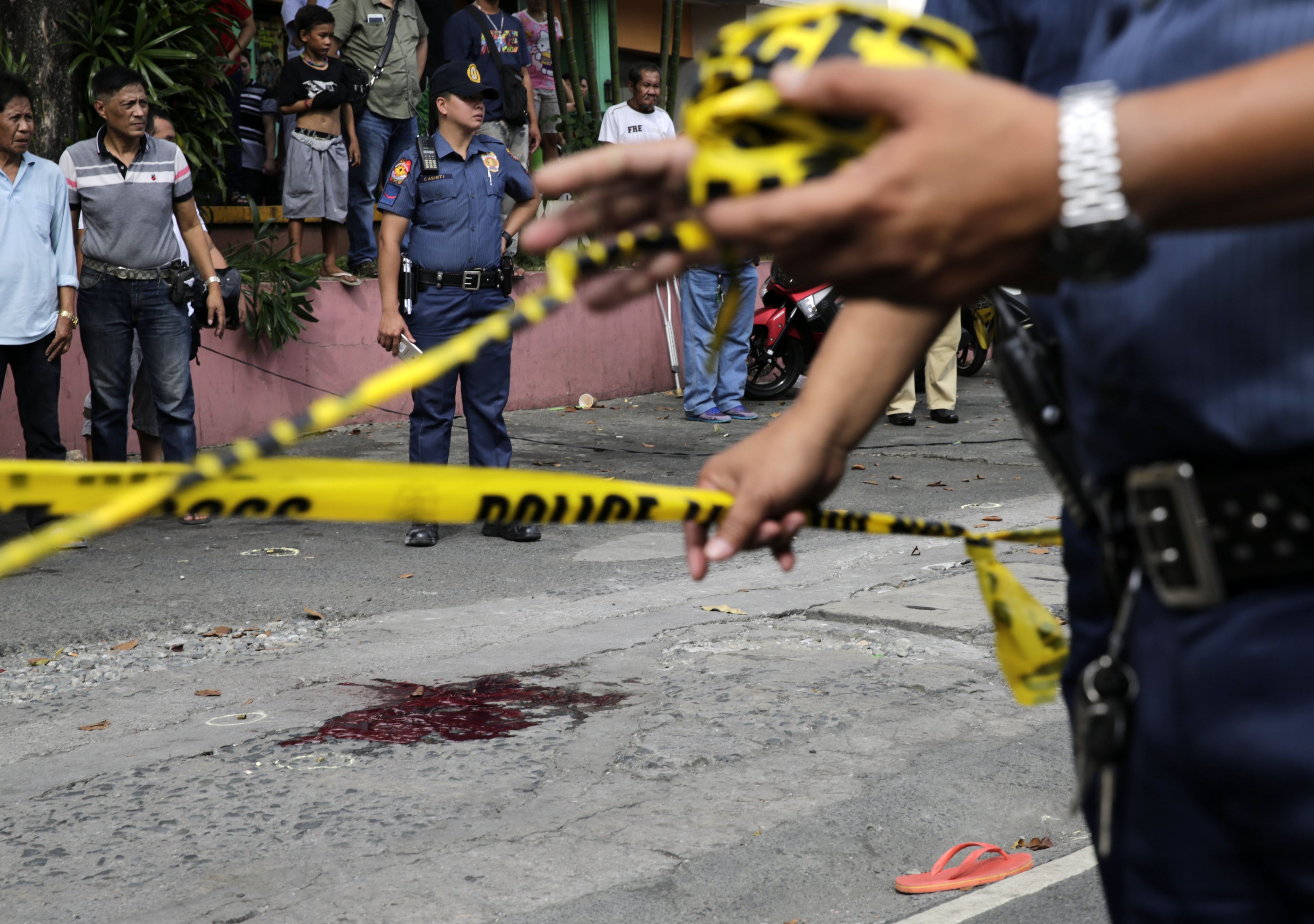 Filipino policemen tape off an area in Manila where a drugs suspect was shot in an alleged extrajudicial killing in 2018. Rights groups say Rodrigo Duterte’s drugs war claimed more than 12,000 lives. Photo: EPA-EFE