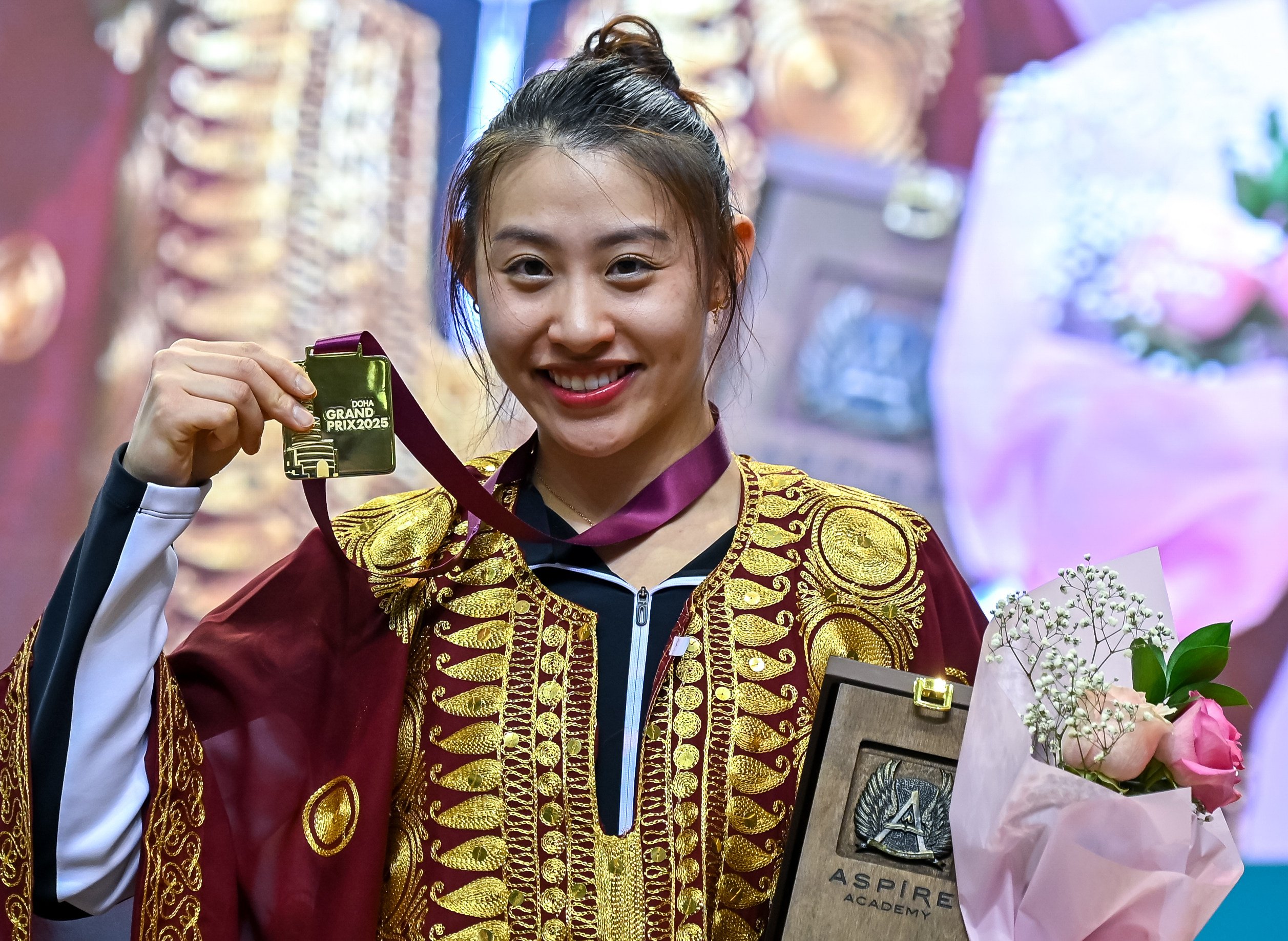 Kaylin Hsieh donning a local Qatari traditional outfit after being awarded her gold medal. Photo: Getty Images 