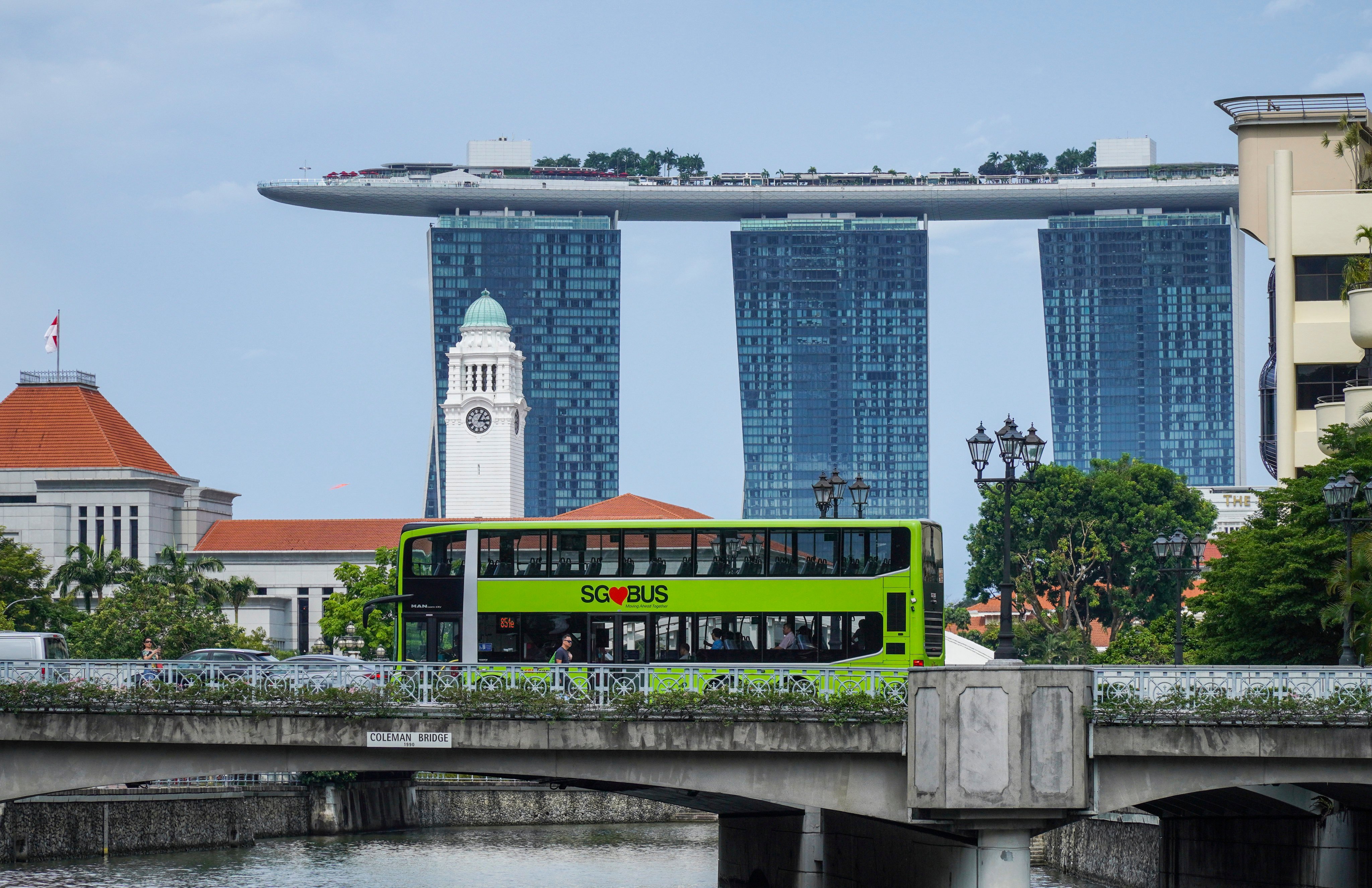 A public bus passes a bridge in Clarke Quay in front of the Marina Bay Sands Hotel in Singapore. Photo: SCMP
