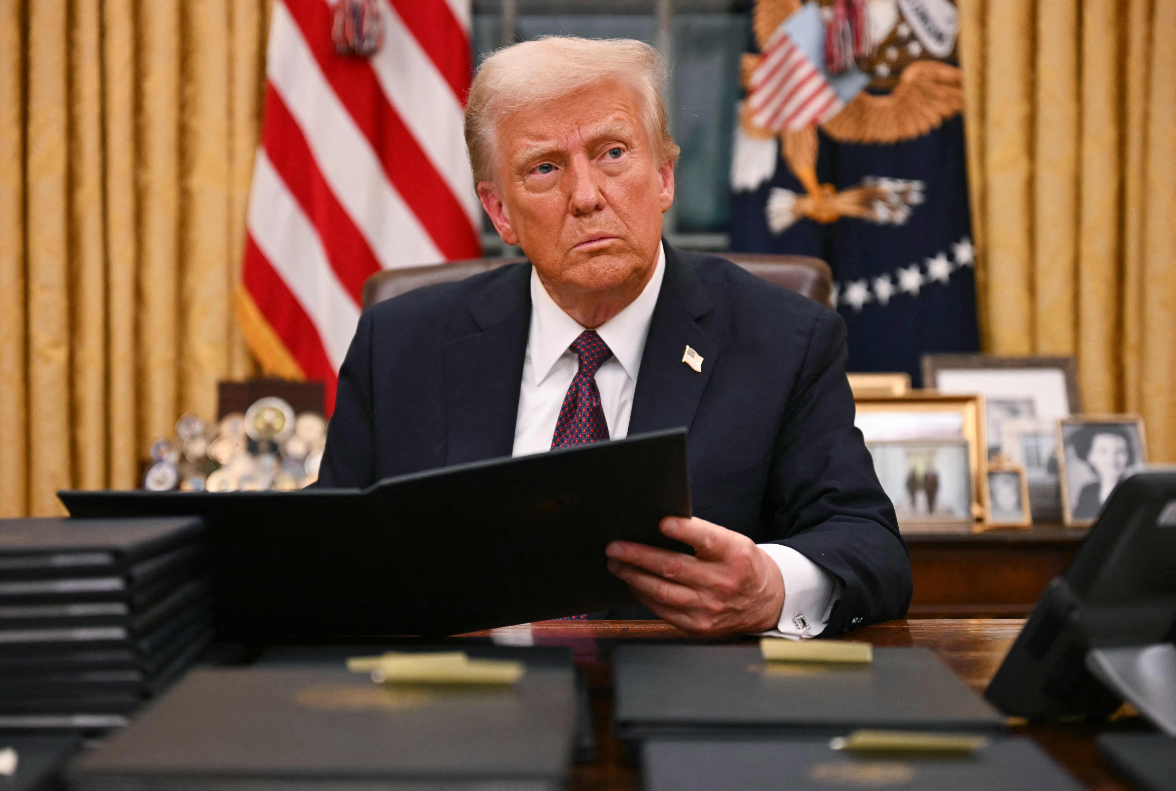 US President Donald Trump signs an executive order in the Oval Office of the White House in Washington, DC, on January 20. Photo: AFP