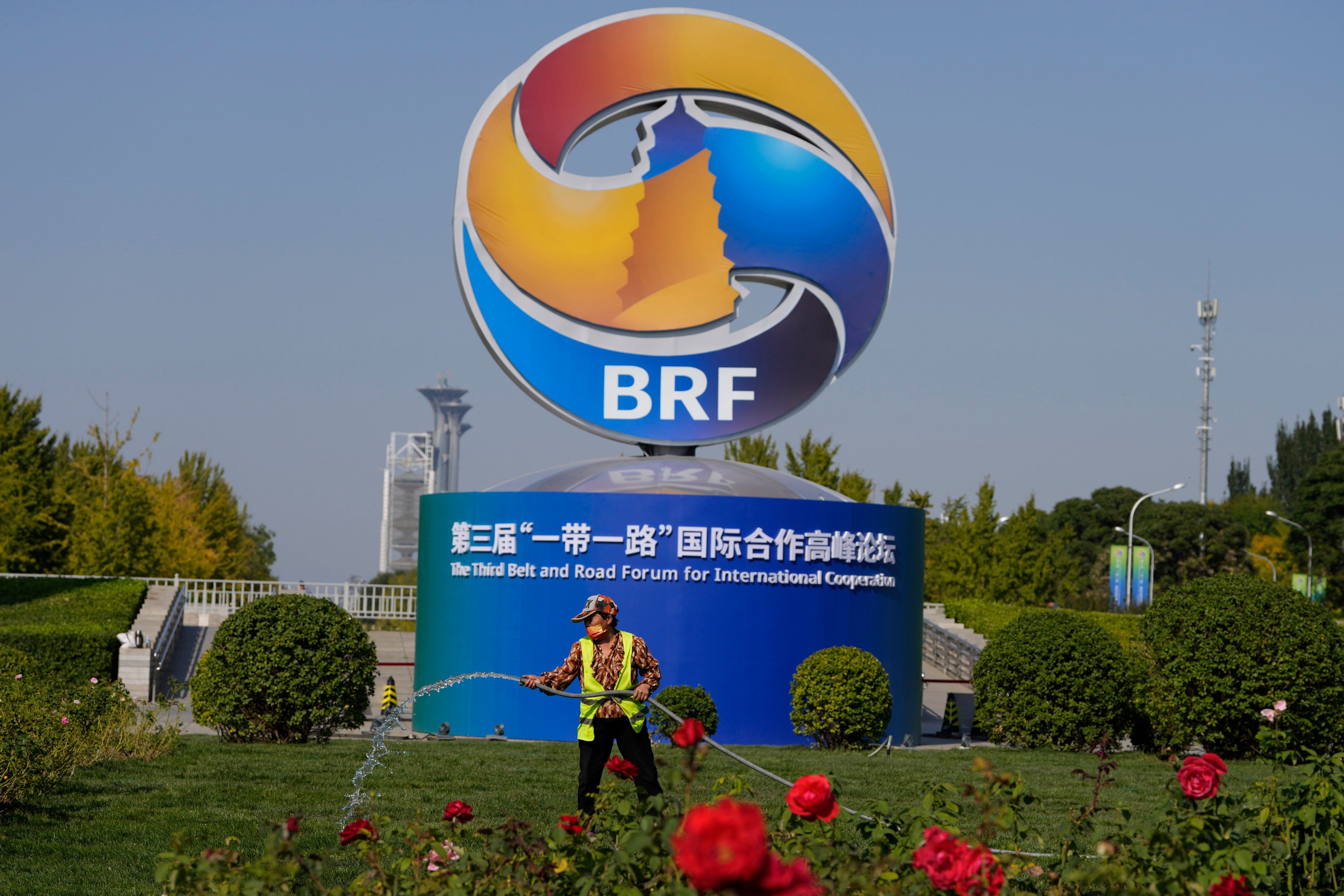 A gardener waters the grass near the logo for the Belt and Road Forum at the China National Convention Center in Beijing, on October 16, 2023. Photo: AP 