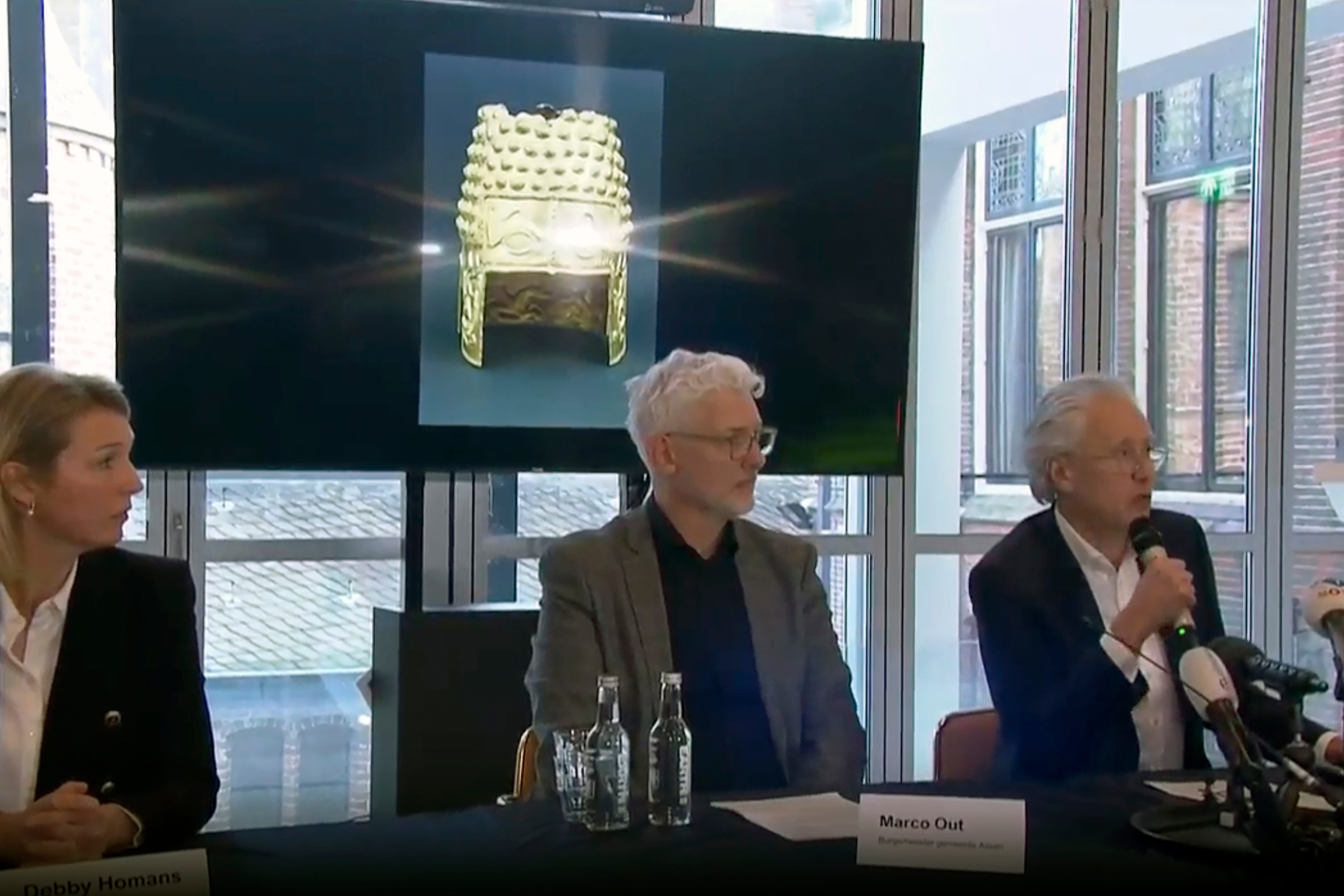 Drents Museum director Harry Tupan (right) speaks during a news conference in front of an image of the ancient golden Cotofenesti helmet, at the Drents Museum in Assen, Netherlands on Saturday. Photo: RTL Nieuws via AP