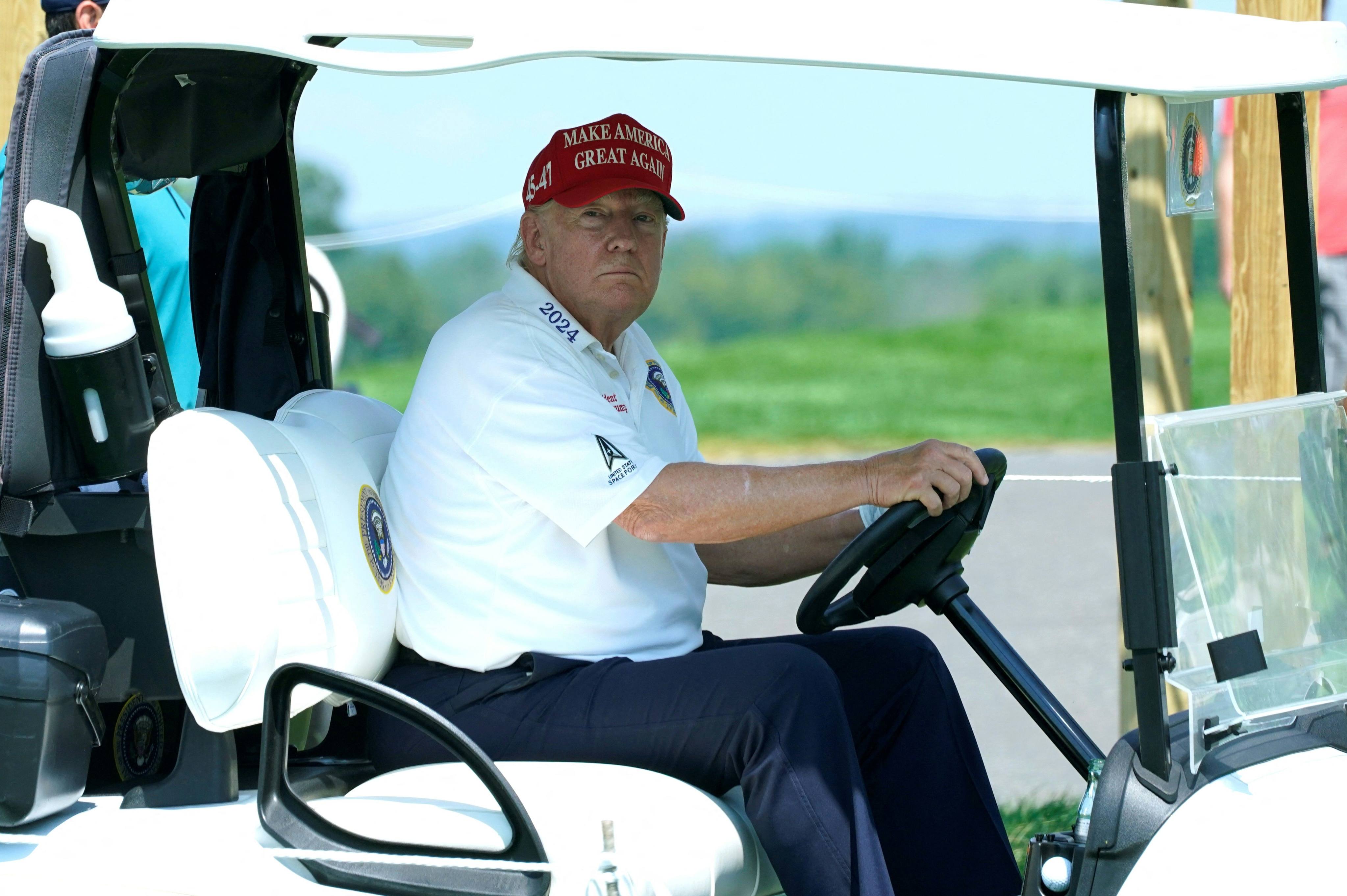 US President Donald Trump drives a golf cart at a tournament in New Jersey, US. His administration has announced plans to hike tariffs on made-in-China buggies by more than 450 per cent. Photo: AFP