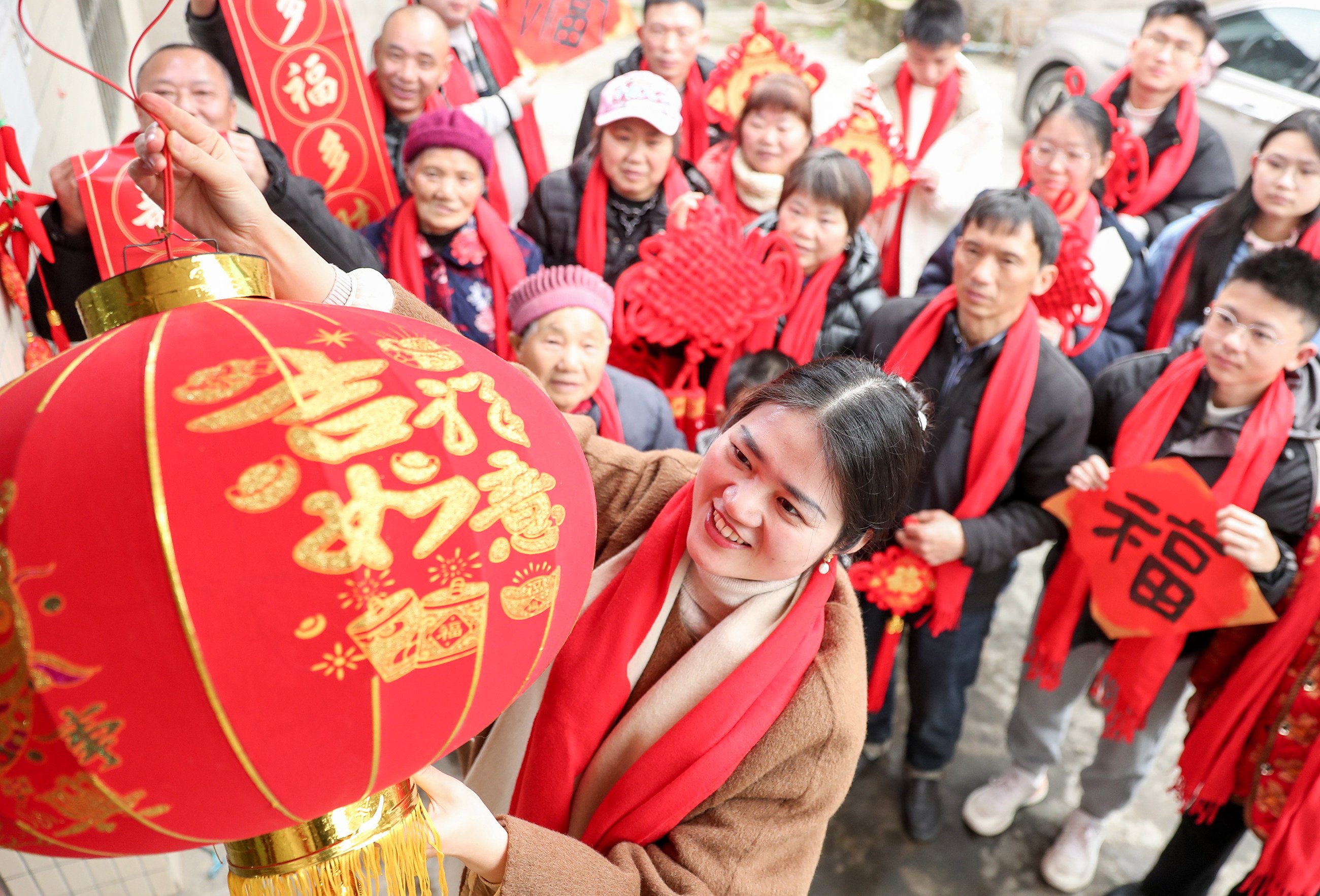 A family hangs a traditional  red lantern Spring Festival decoration in a village in Huaying, Sichuan province, on Thursday. Photo: Xinhua