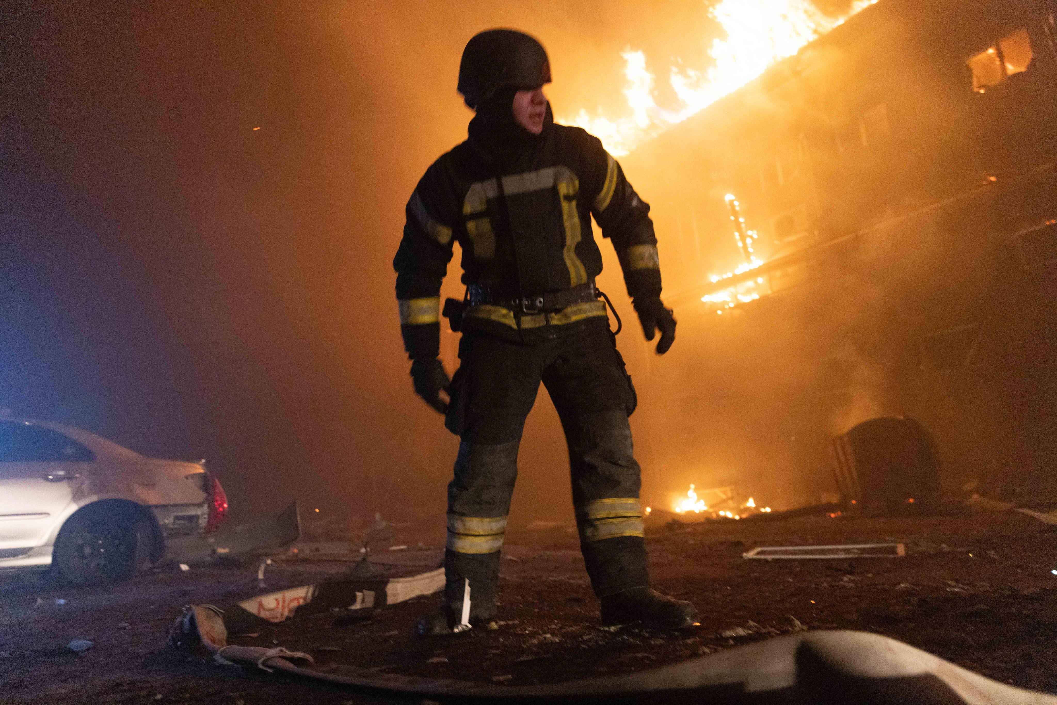 A firefighter looks on as flames erupt from a building in Ukraine following a Russian strike on Tuesday. Photo: Zuma Press Wire/dpa