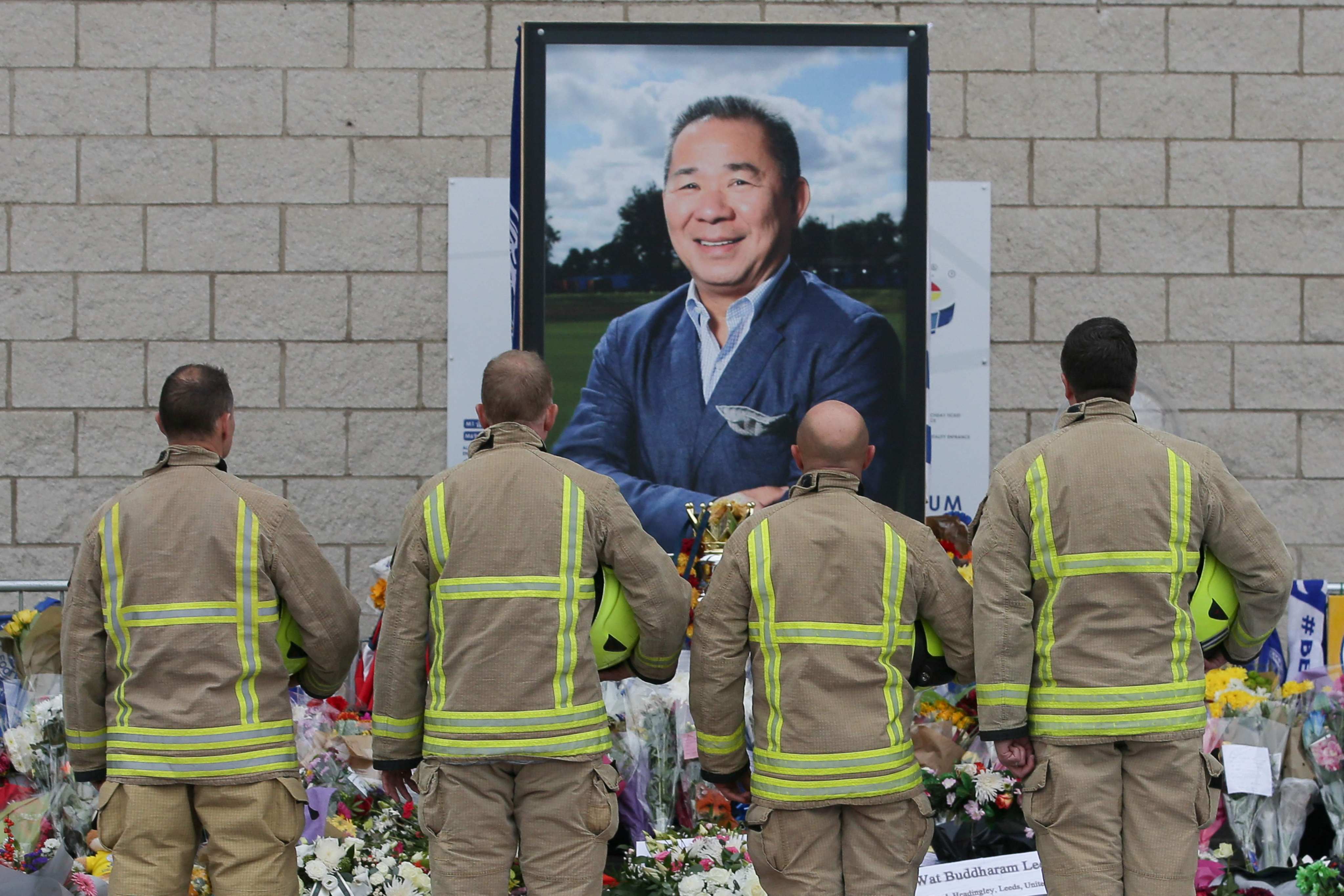 Firefighters pay their respects in front of a portrait of Leicester City Thai chairman Vichai Srivaddhanaprabha following his death in 2018. Photo: AFP