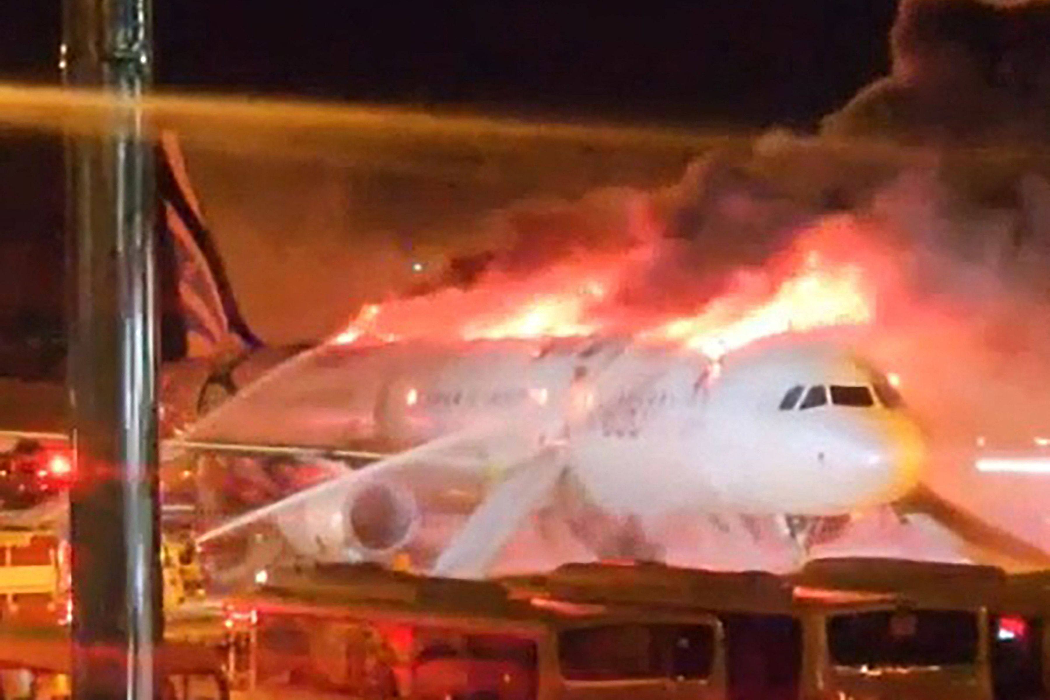 Firefighters work to extinguish a fire that broke out on an Air Busan passenger plane at Gimhae International Airport in Busan on Tuesday night. Photo: Yonhap via AFP