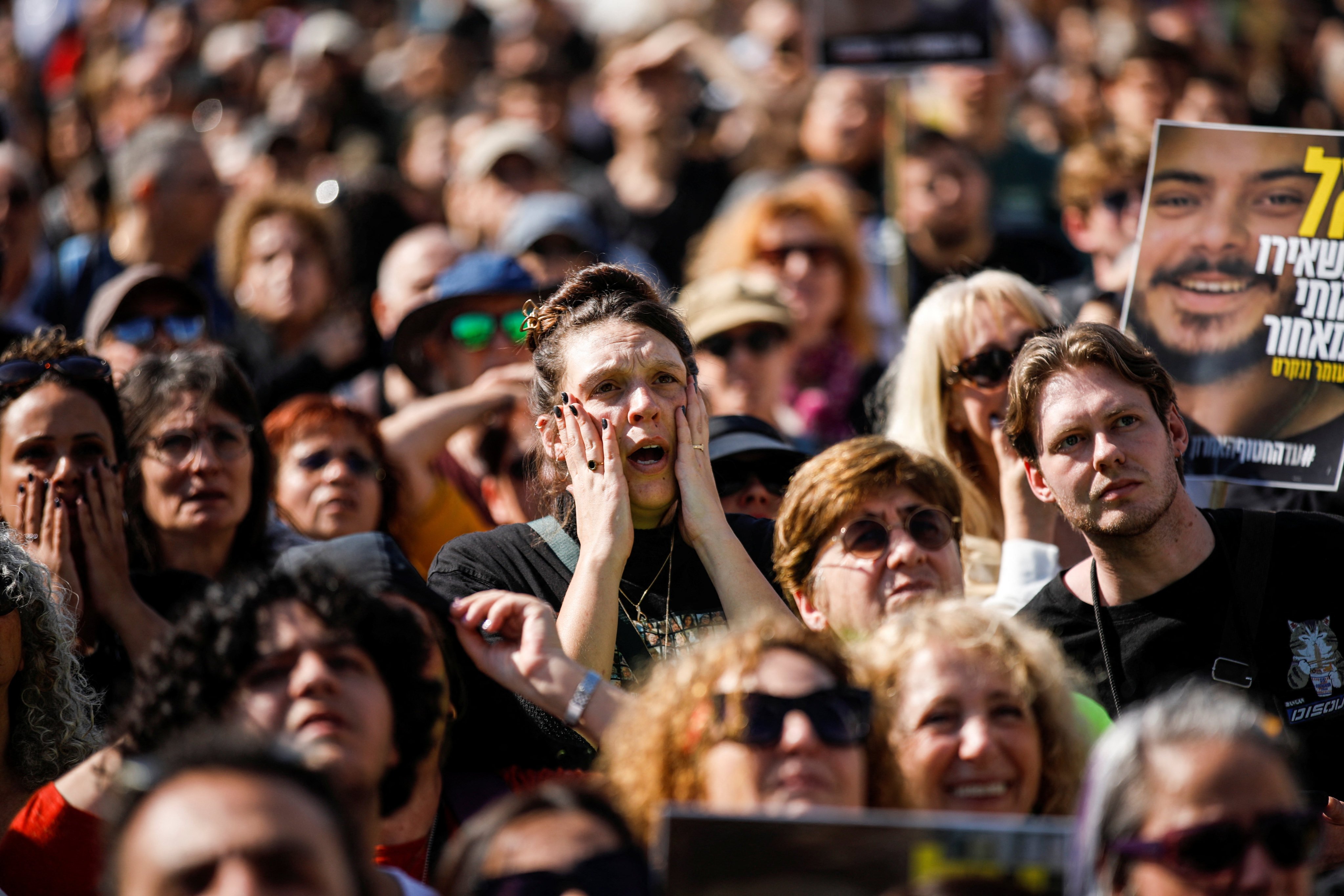 People watch news coverage on the day of the release of hostages held in Gaza, in Tel Aviv on January 30. Photo: Reuters