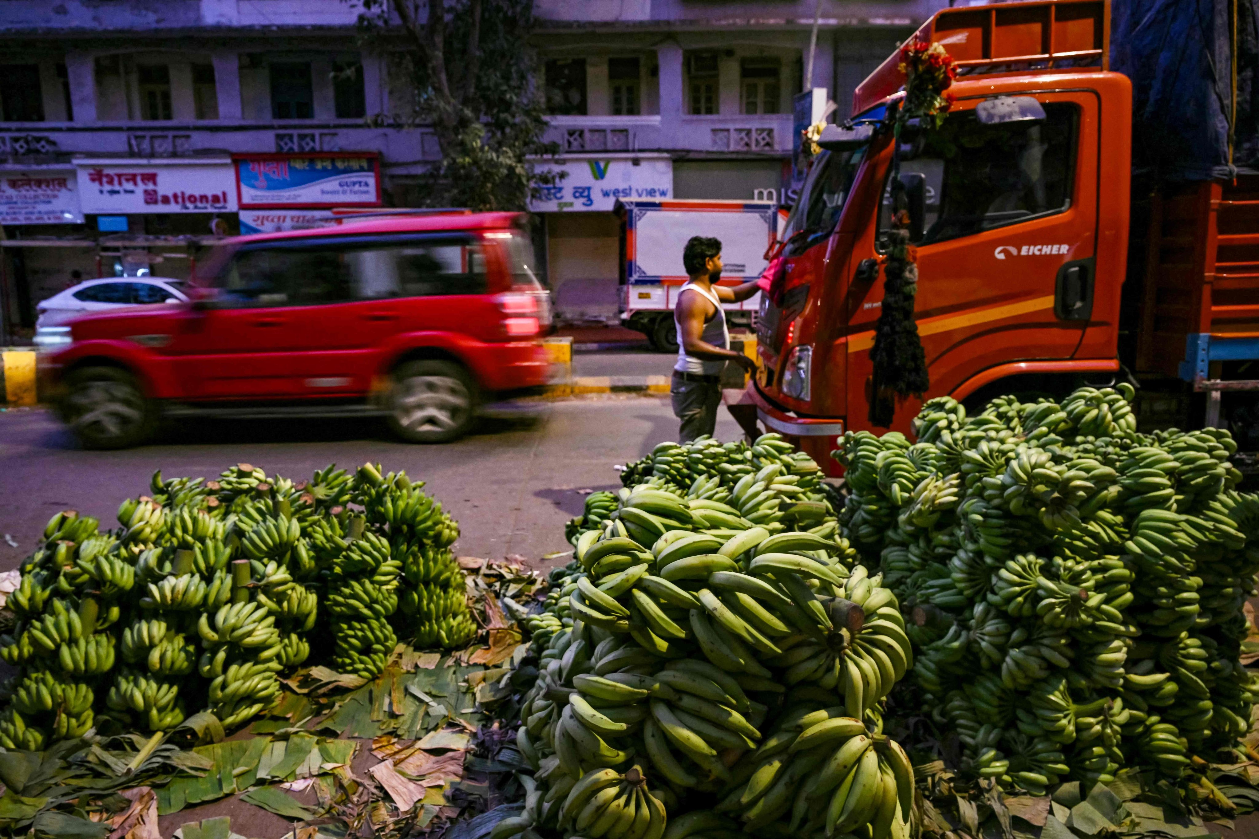 A driver cleans his truck before loading stalks of bananas outside a market, at dawn in Mumbai on Tuesday. India’s economic growth is expected to remain at 6.5 per cent through this year and the next. Photo: AFP