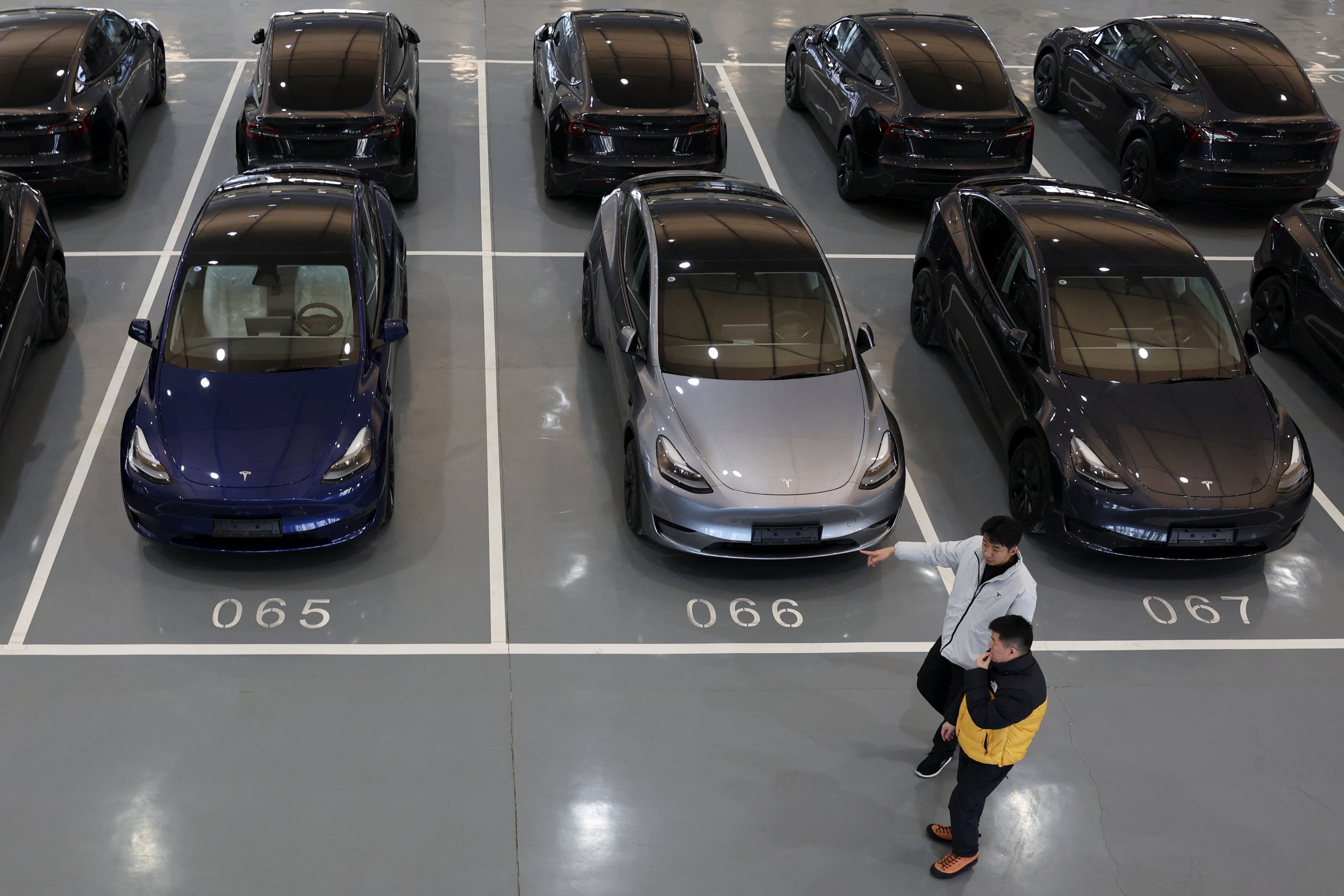 People walk past Teslas at a delivery centre in Beijing. Photo: Reuters 