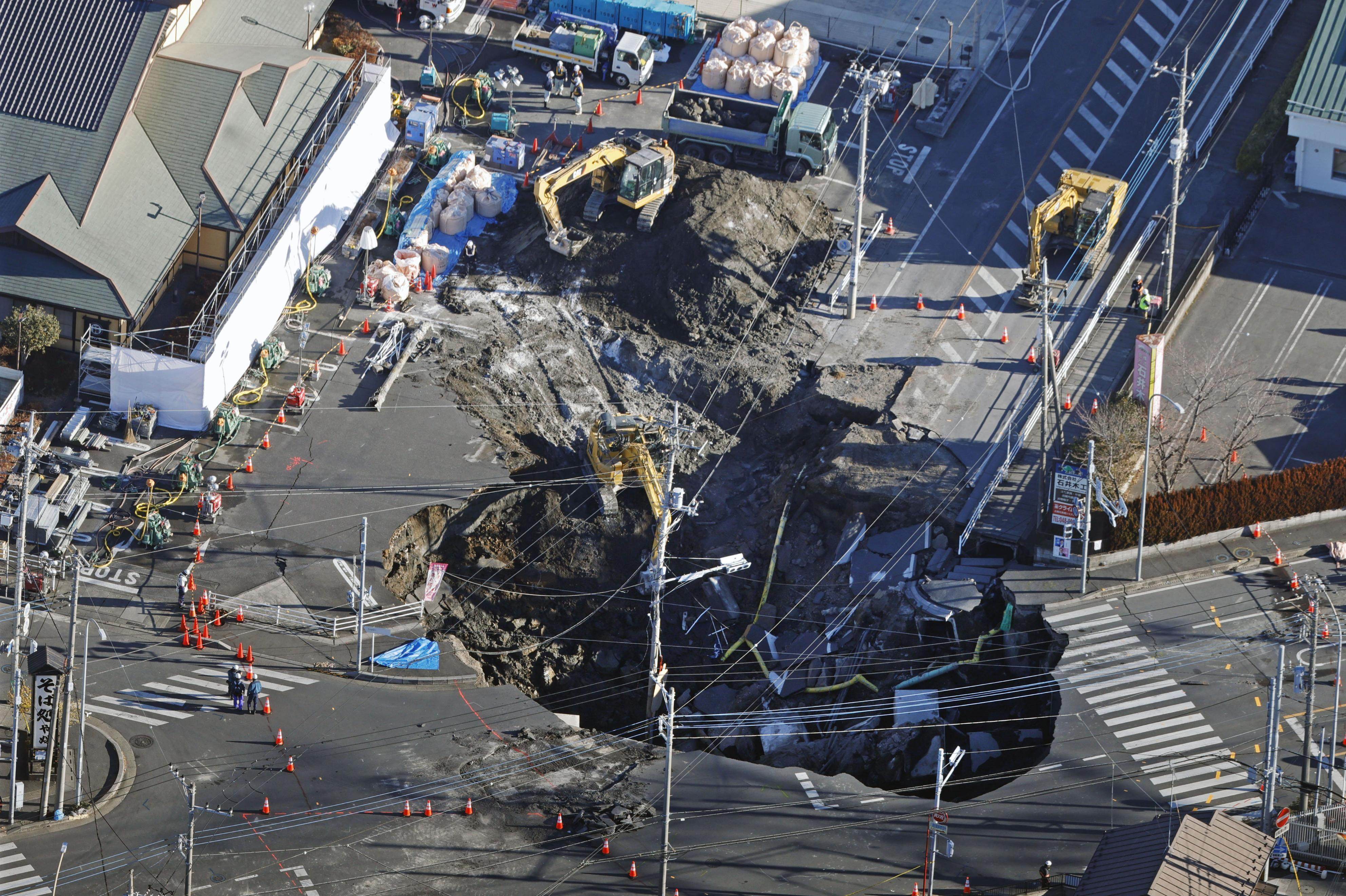 A huge sinkhole in Yashio in Saitama Prefecture, near Tokyo, photographed from a helicopter on Friday. The hole appeared on Tuesday, swallowing a truck and its driver, and has enlarged. Photo: Kyodo