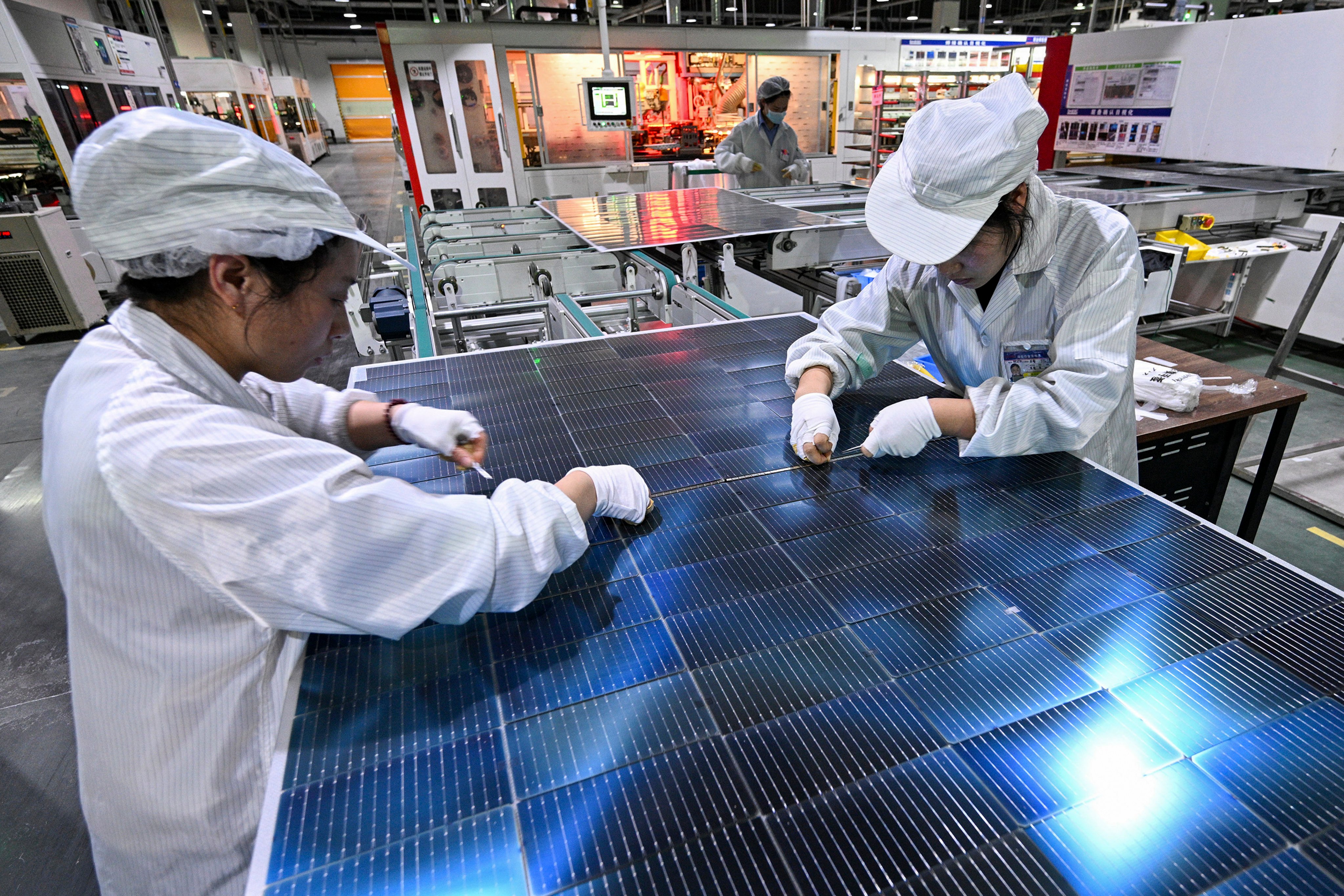 Workers prepare solar panels at a production factory in Sihong county, in east China’s Jiangsu province, on January 23. Photo: Chinatopix via AP