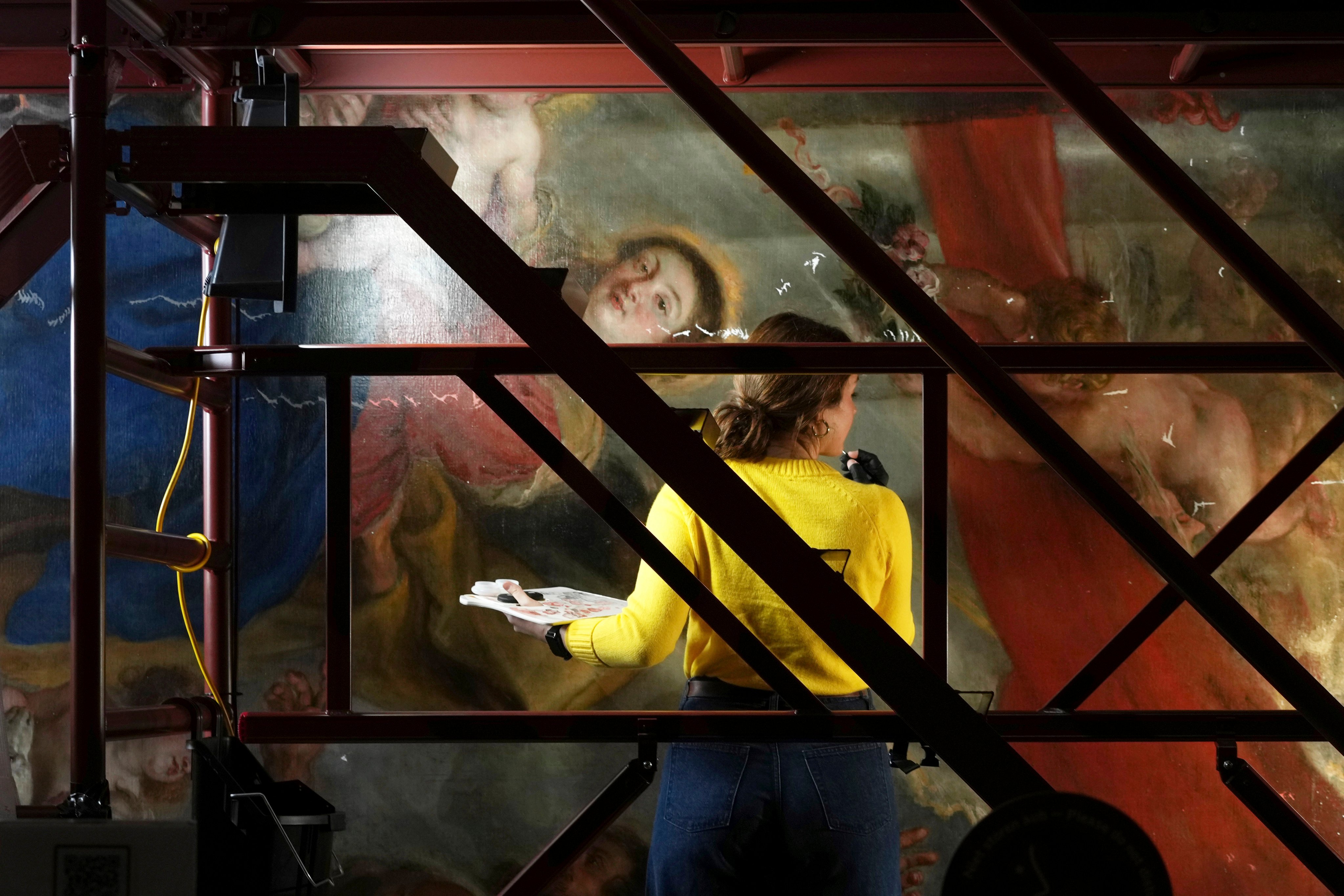 Art conservator Kayla Metelenis works on a section of Enthroned Madonna Adored by Saints, painted by Rubens. Photo: AP