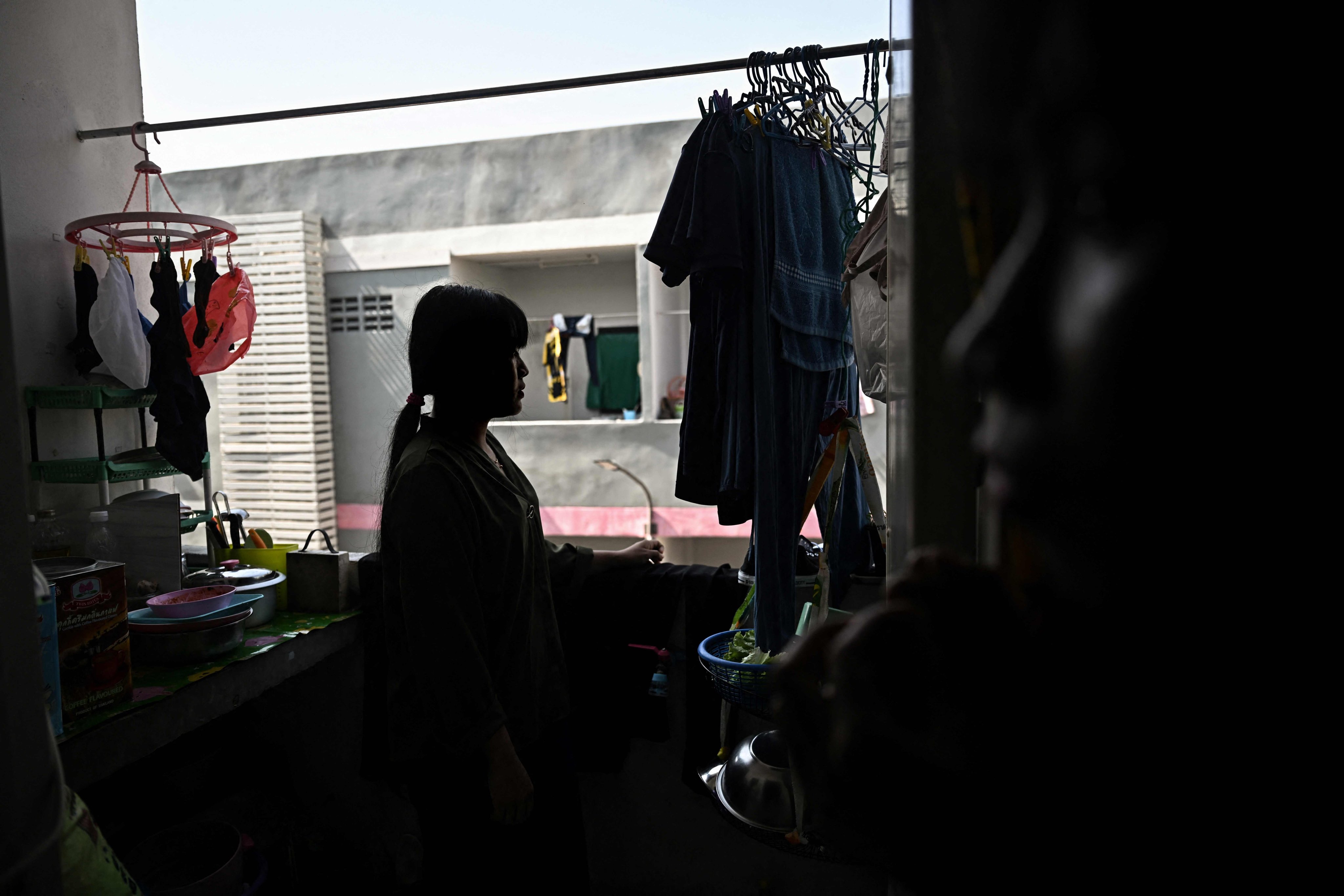 A Myanmar migrant worker looks out her flat window in Samut Sakhon province, Thailand. Photo: AFP