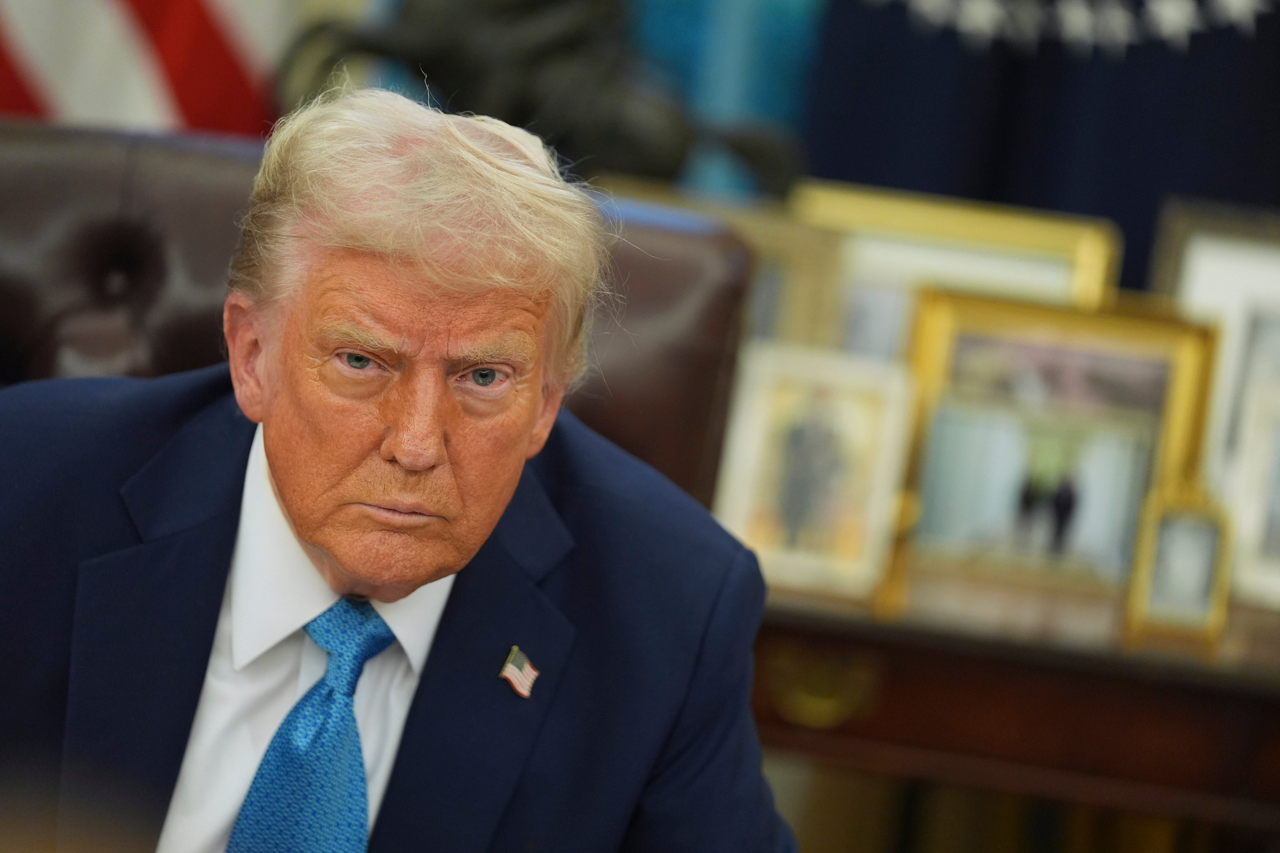 US President Donald Trump speaks to reporters as he signs executive orders in the Oval Office on Friday. Photo: AP