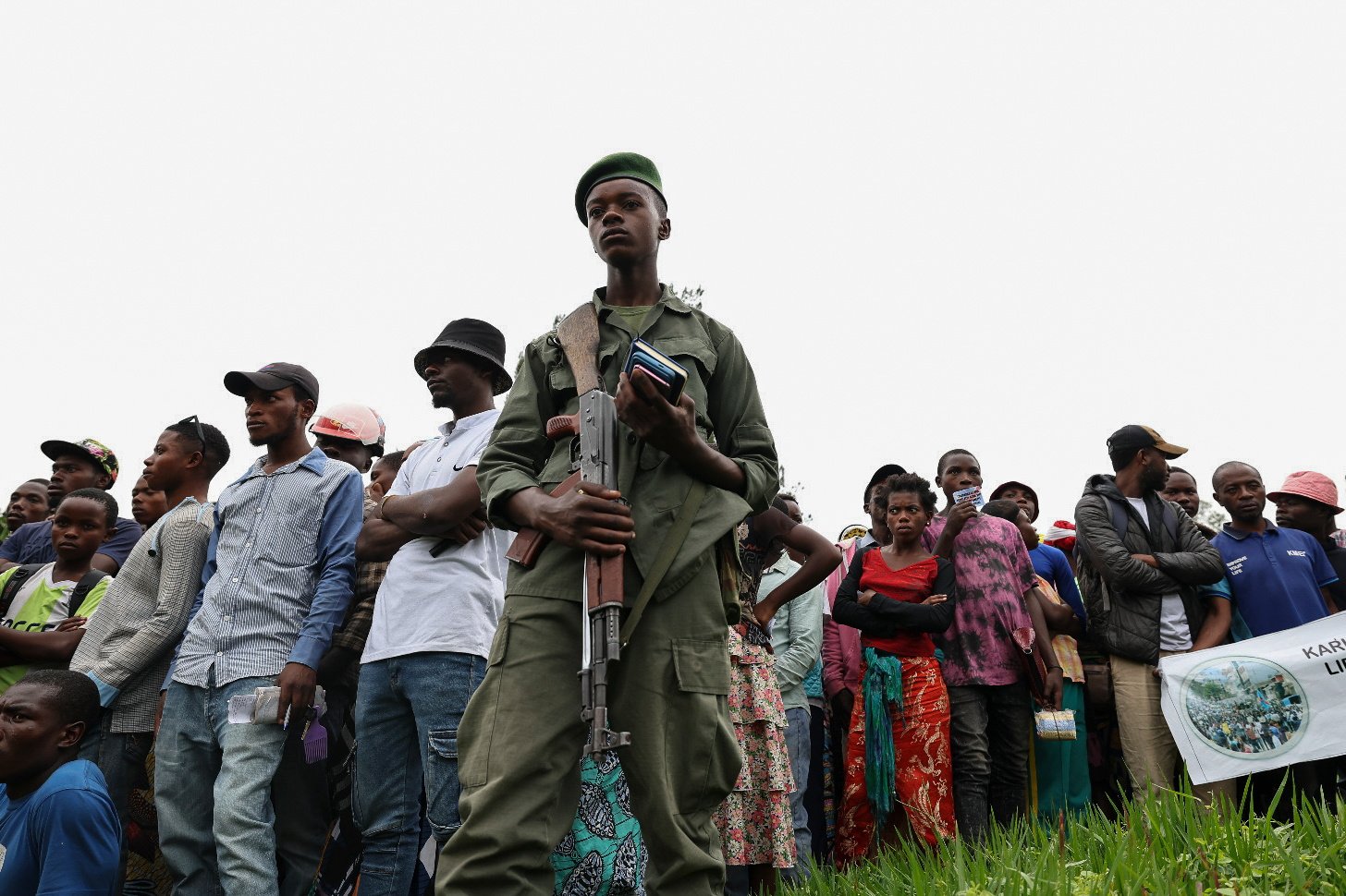 A member of the M23 armed group stands guard as residents come out to celebrate the takeover of the city by the M23 at the Governor’s office compound in Goma, Democratic Republic of the Congo, on Friday. Photo: EPA-EFE