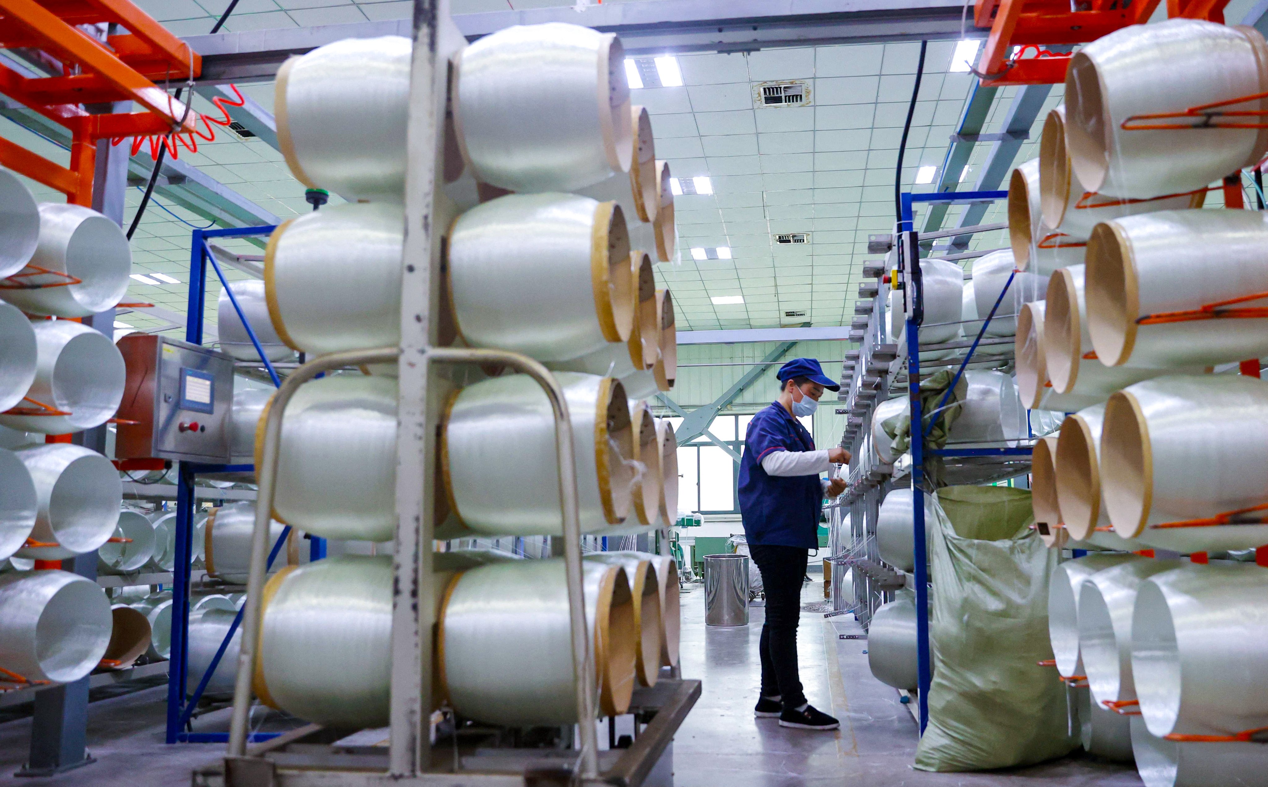 A worker checks rolls of glass fibre at a factory in Chongqing. Growth in China’s manufacturing sector unexpectedly declined sharply in January, according to a new report. Photo: AFP