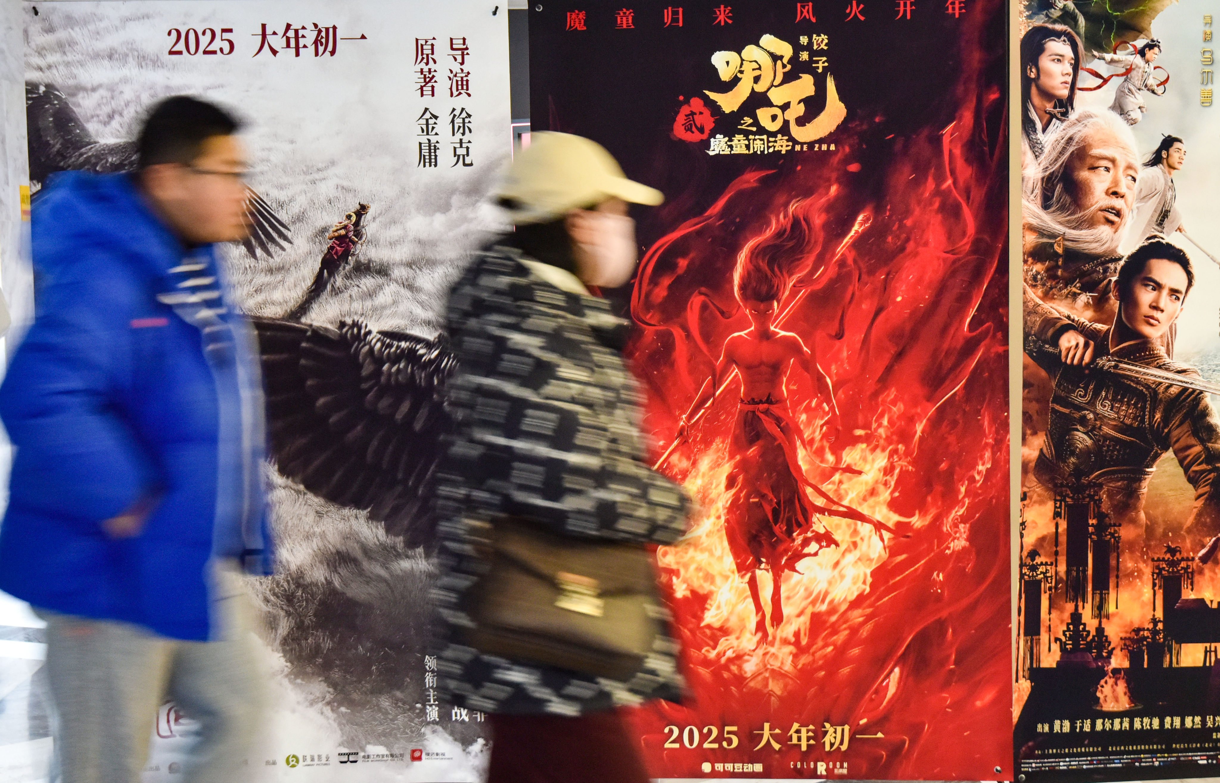 Moviegoers walk past posters of the films Legends of the Condor Heroes: The Gallants, Ne Zha and Creation of the Gods II: Demon Force at a cinema in Fuyang during the Lunar New Year. Photo: Getty Images