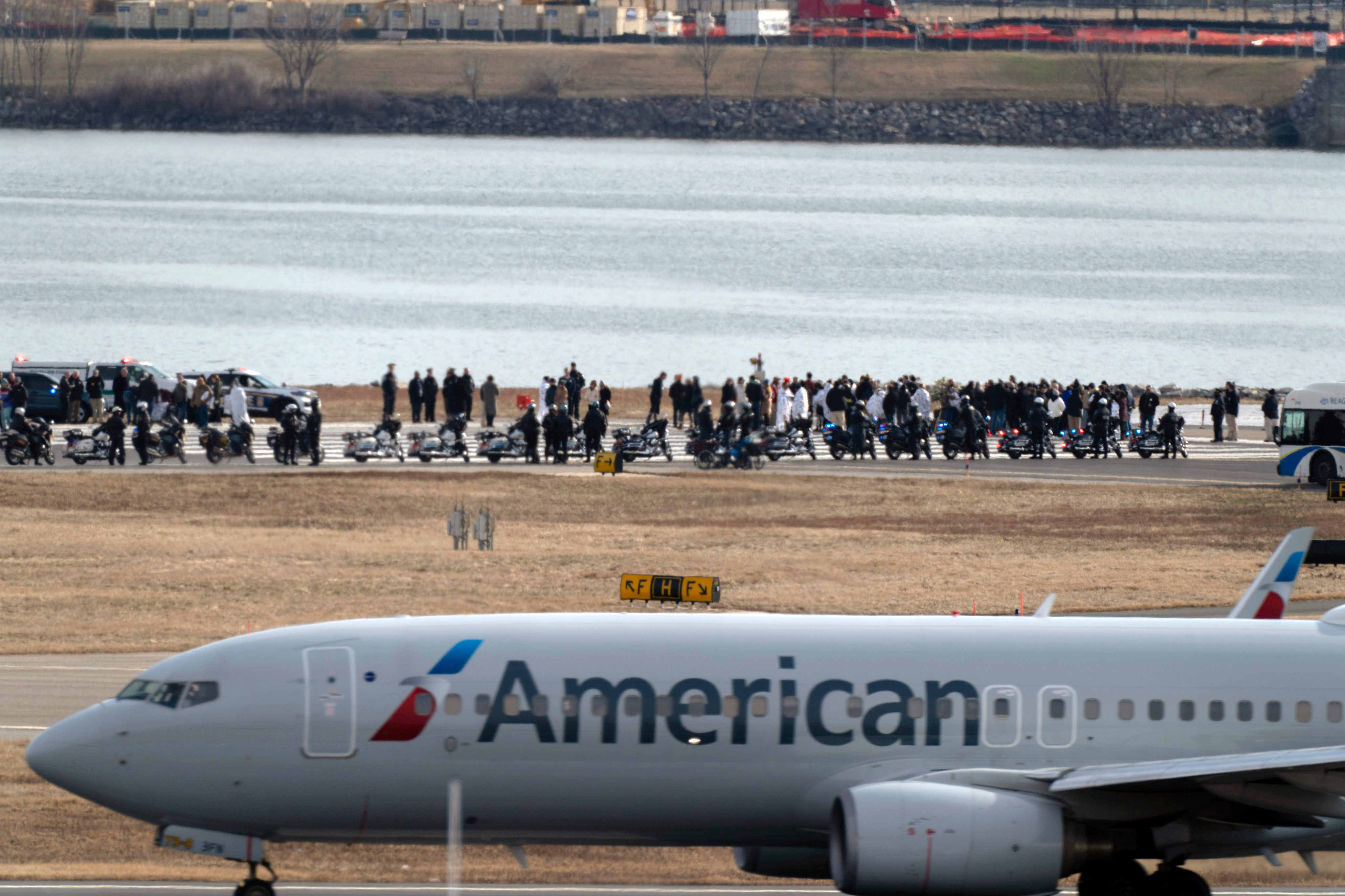 An American Airlines jet passes as families of the victims of last week’s mid-air collision stand near the crash site at Ronald Reagan Washington National Airport in Arlington, Virginia on Sunday. Photo: AP