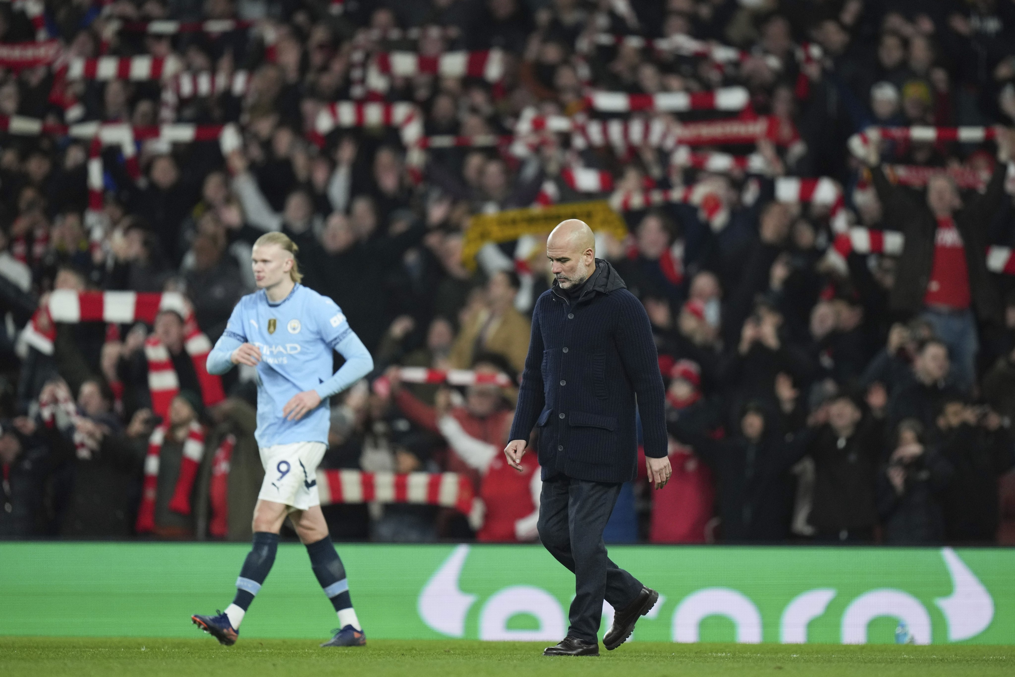 Manchester City’s head coach Pep Guardiola and Erling Haaland leave the pitch after being well beaten by Arsenal. Photo: AP