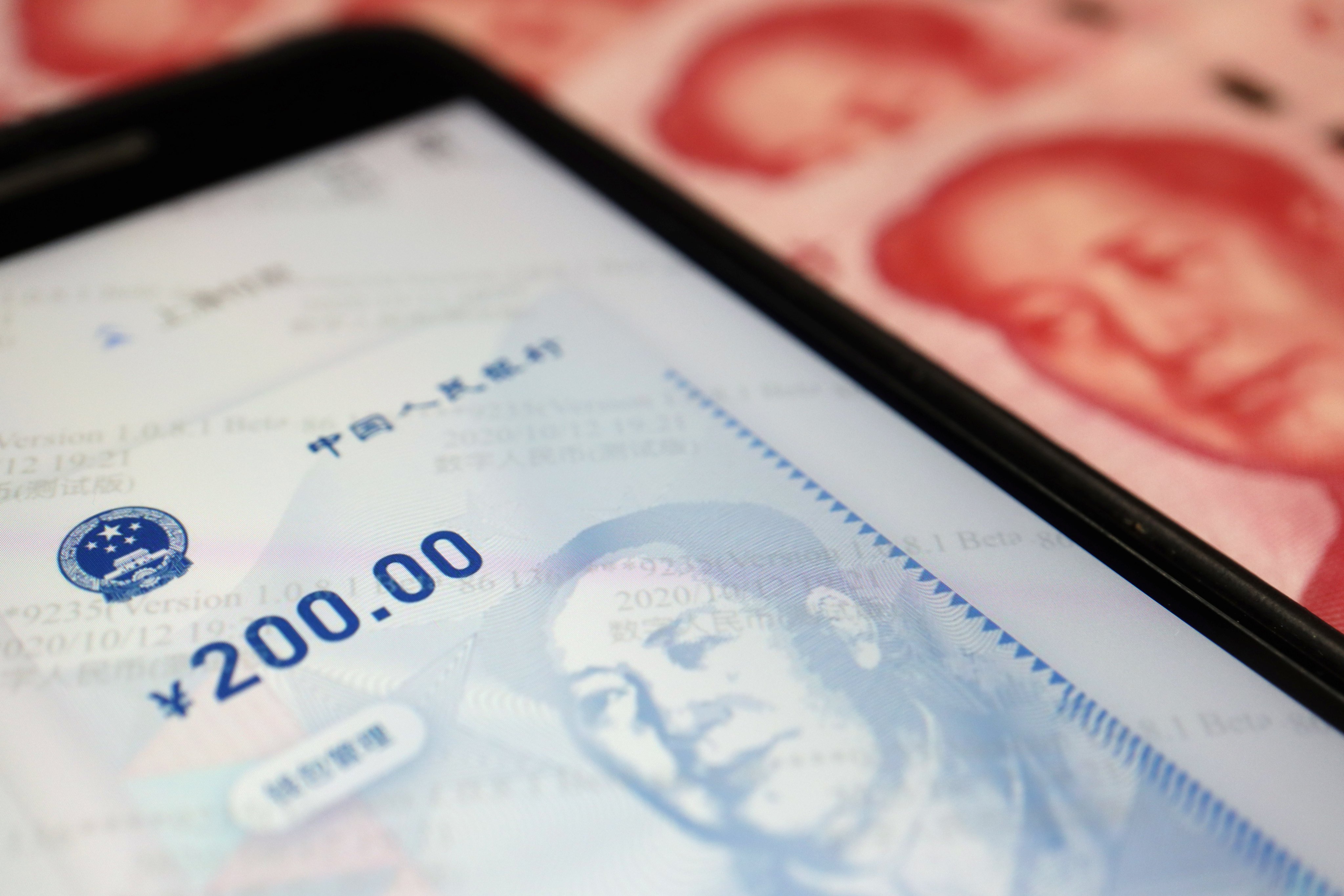 China’s app for the digital yuan is seen on a mobile phone next to 100-yuan banknotes. Photo: Reuters