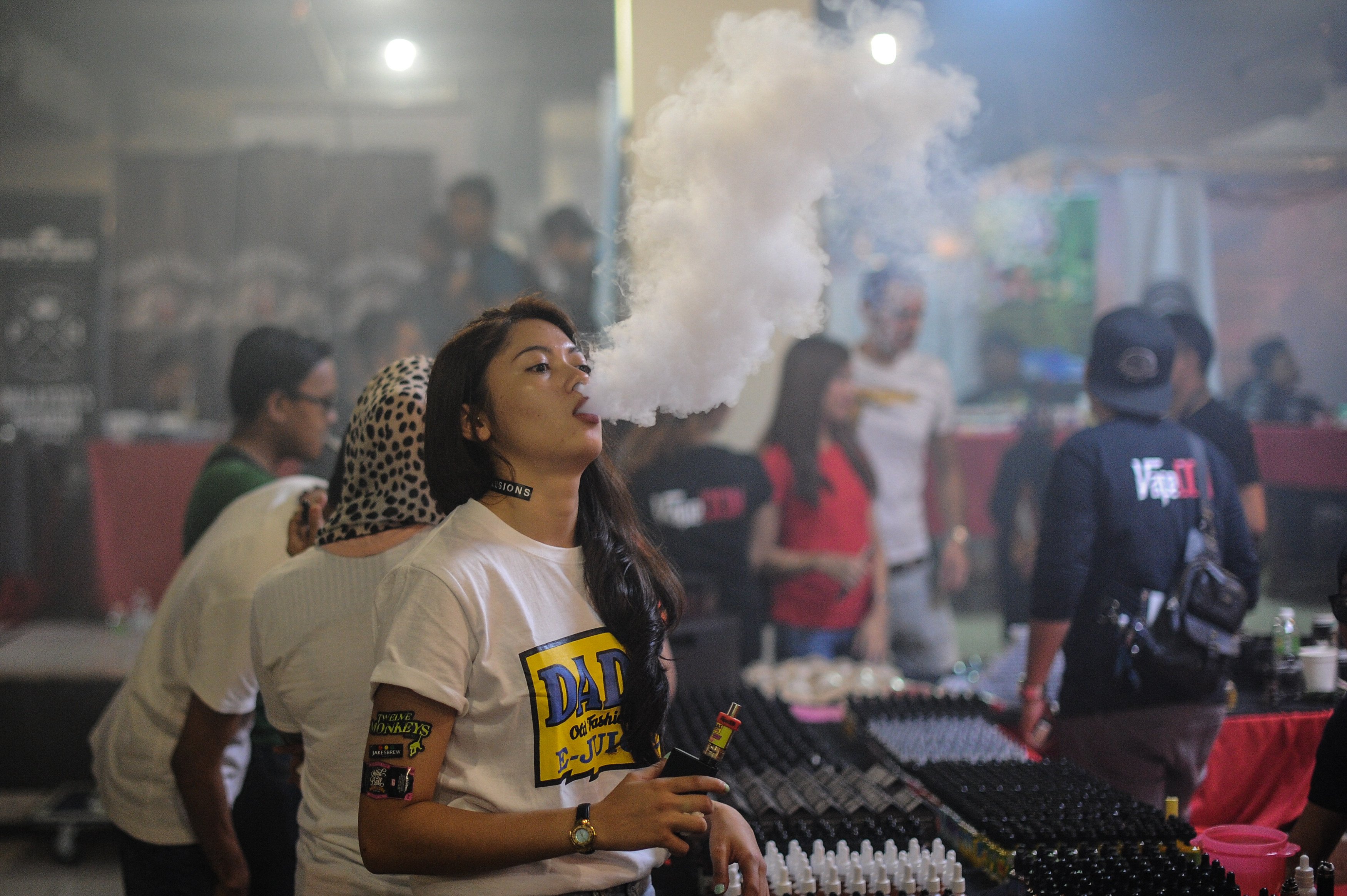 A woman smokes an electronic cigarette during a vaping fair in Kuala Lumpur. Photo: AFP