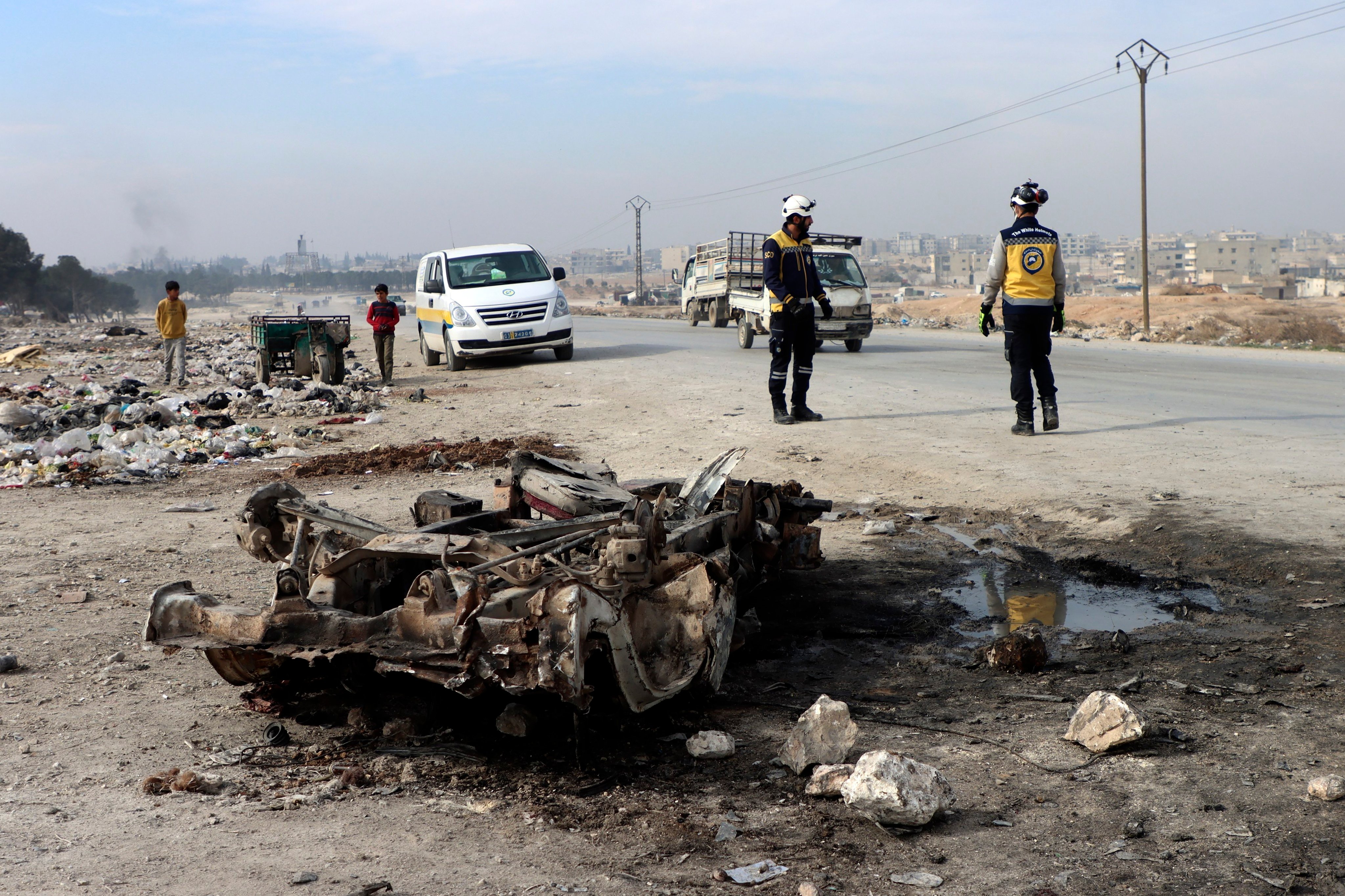 Syrian White Helmet civil defence workers inspect the site of a car bomb attack on the outskirts of Manbij, Syria on Monday. Photo: Syrian Civil Defence White Helmets via AP