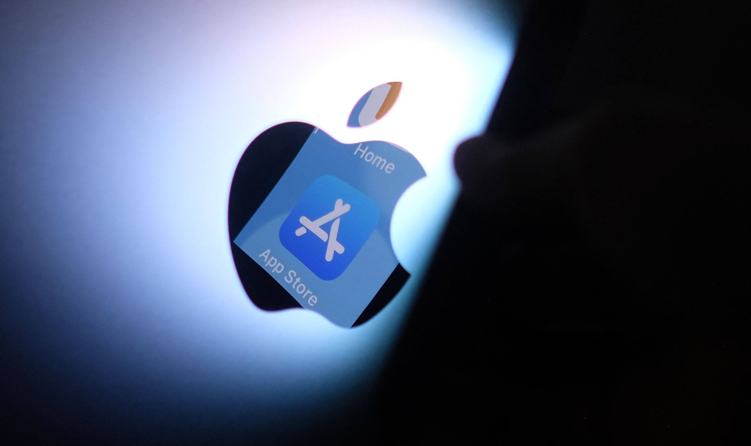 The Apple App Store logo is seen reflected from an iPhone onto the back of an iMac. Photo: AFP