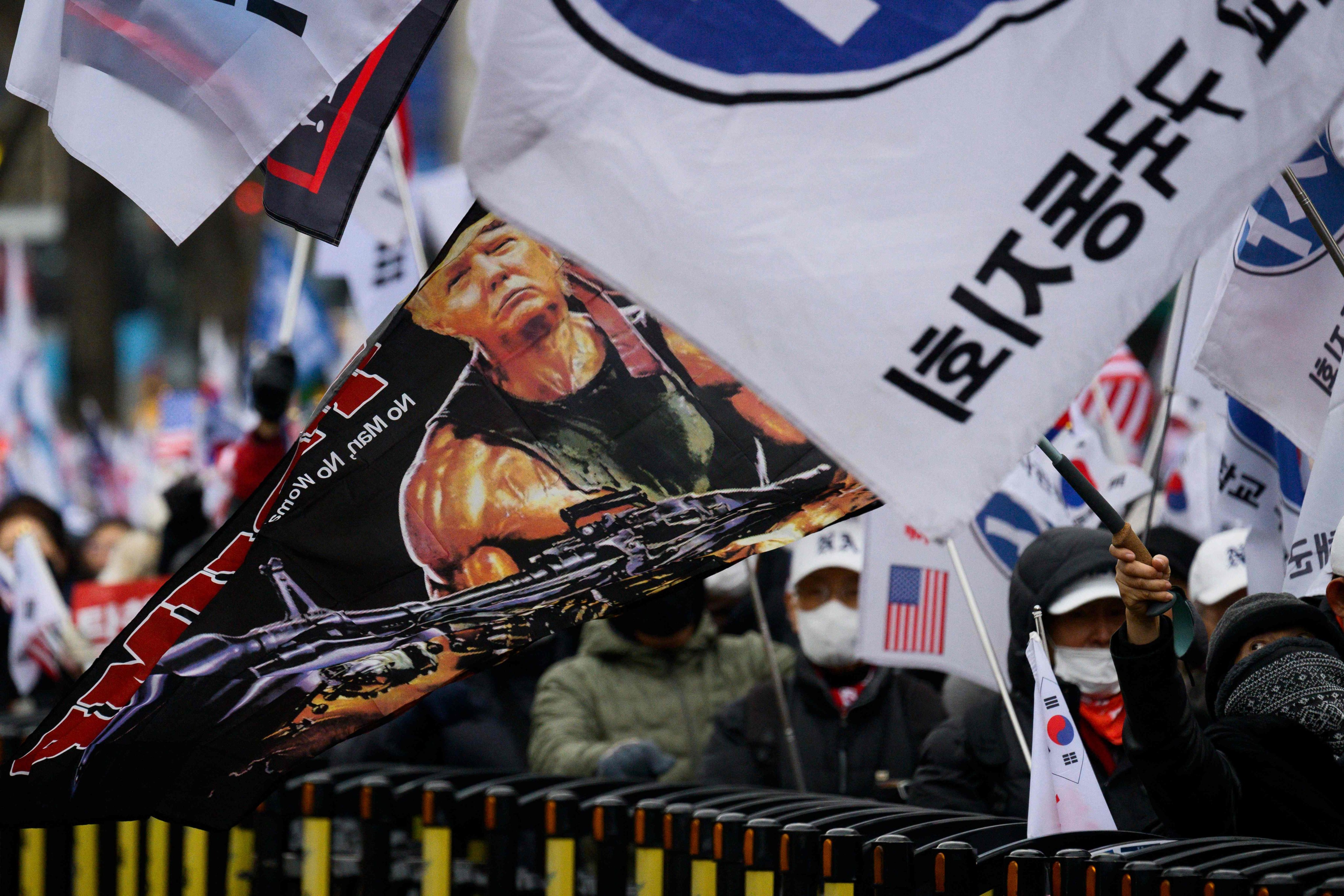 A flag showing Donald Trump depicted as Rambo is held by a supporter of impeached South Korean President Yoon Suk-yeol during a rally in Seoul on January 16. Photo: AFP