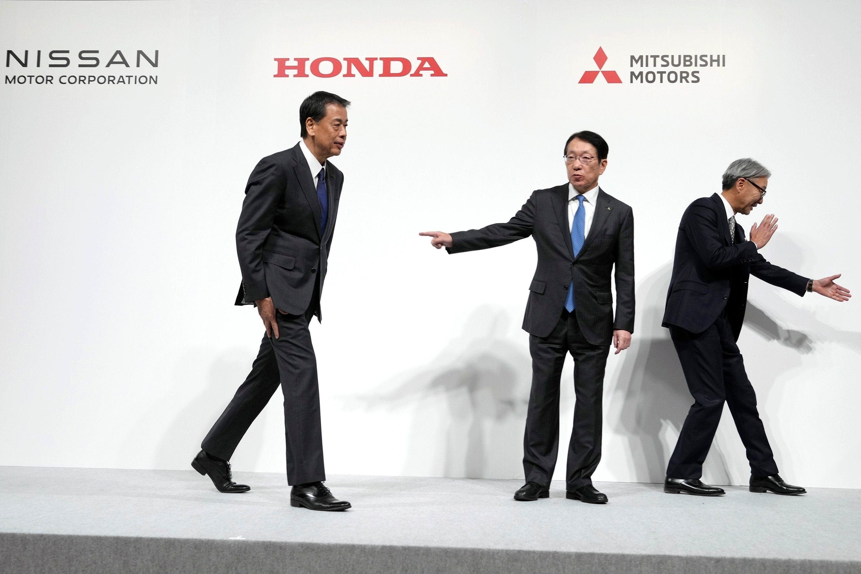 Nissan Motors’ Chief Executive Makoto Uchida (left),Takao Kato, CEO of Mitsubishi Motors (center), and Honda Chief Executive Toshihiro Mibe (right), leave after a joint news conference in Tokyo on December 23, 2024. Photo: AP