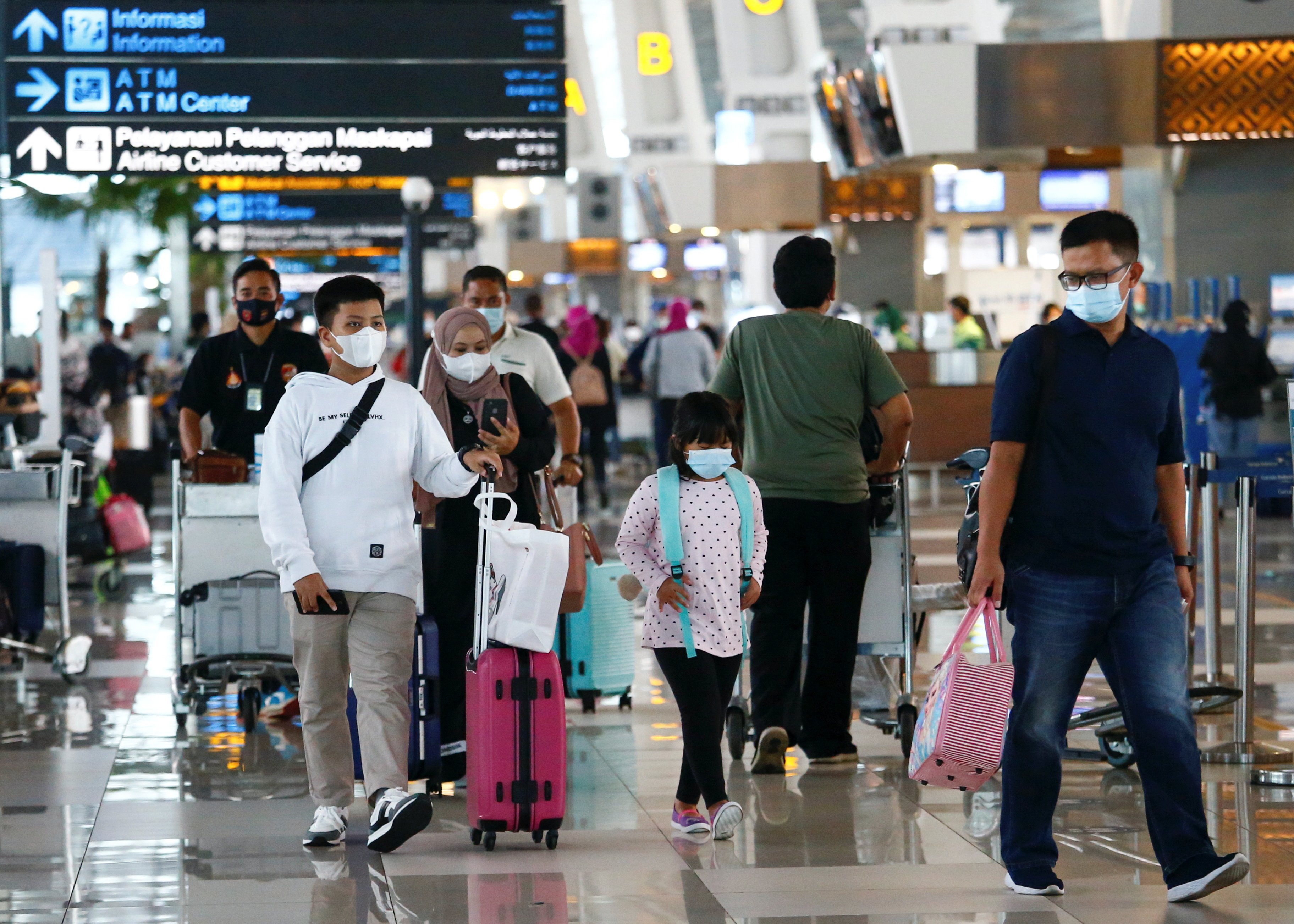 People walk with their luggage at Soekarno-Hatta Airport in Jakarta. Photo: Reuters