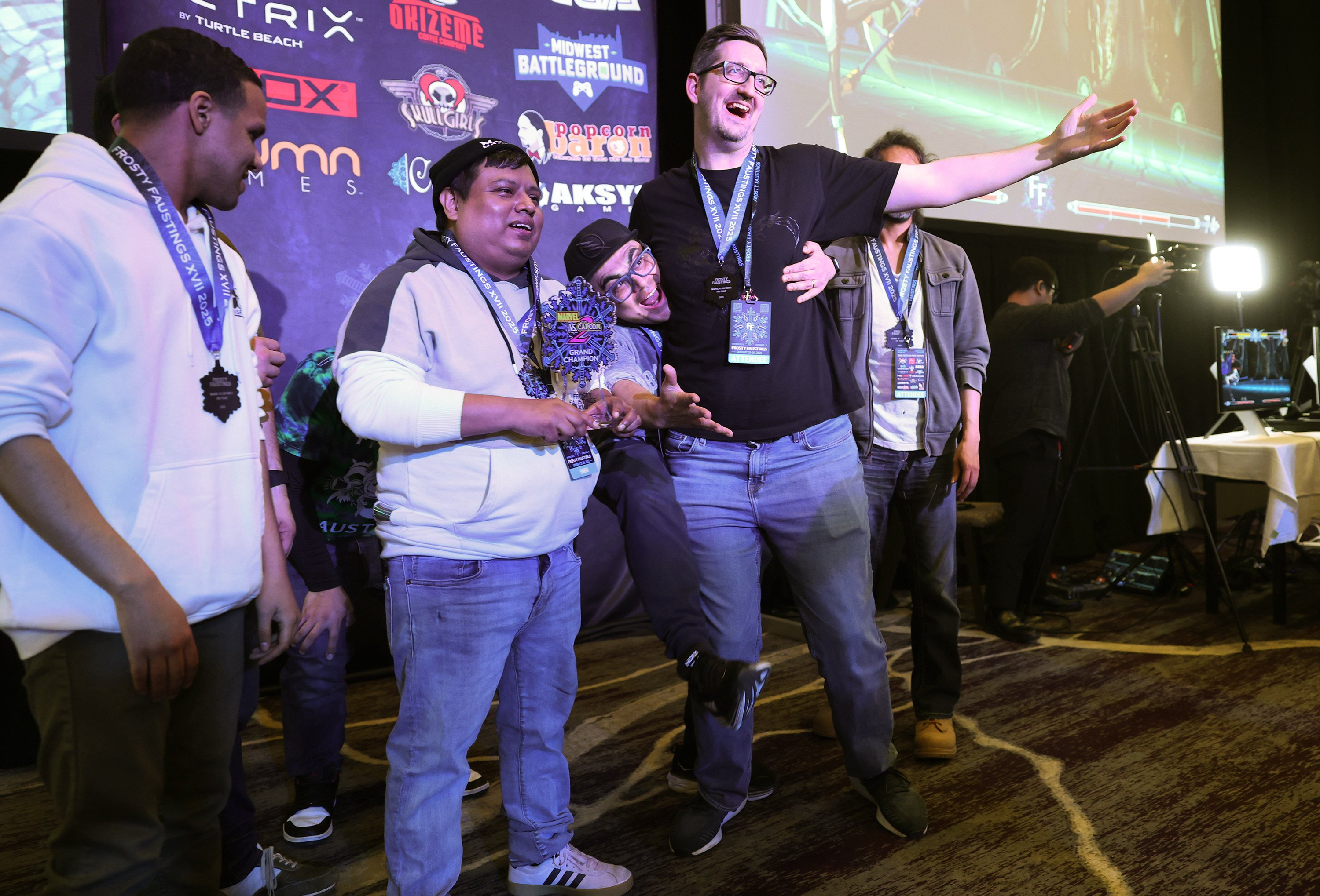 James “Shakira” Martinez (second left) holds the championship trophy for winning the Marvel vs. Capcom 2 tournament at Frosty Faustings XVII at the Westin Chicago Lombard hotel on January 24, 2025, in Lombard, Illinois, US. Other Top 8 finishers included David “Dave Blaine” Thacker (left),  Jacob “Jacobpat84” Tranaude (in black T-shirt) and Jose “DJ Vest” Dominguez (behind Tranaude). Photo: TNS